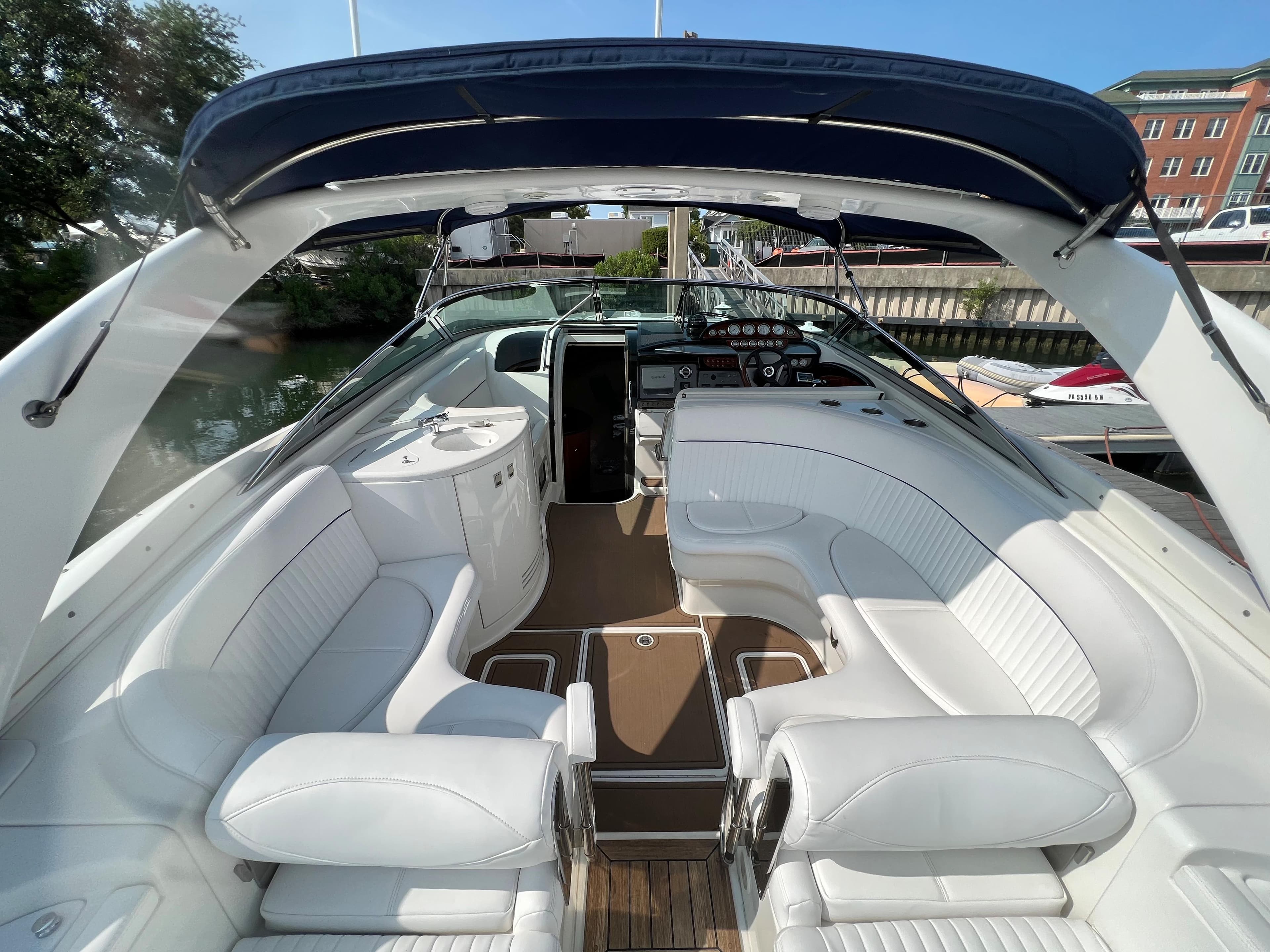 2004 Cobalt 360 boat with white leather seating and blue canopy.