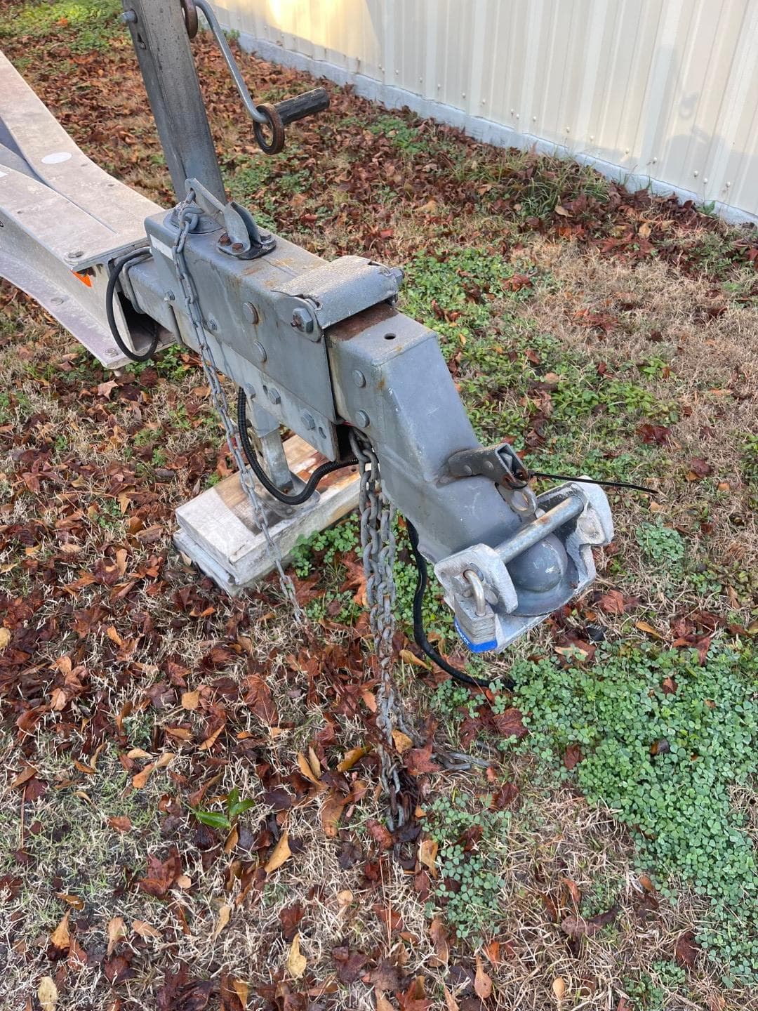 Trailer hitch of a 2011 Custom Downeast on grass with fallen leaves.