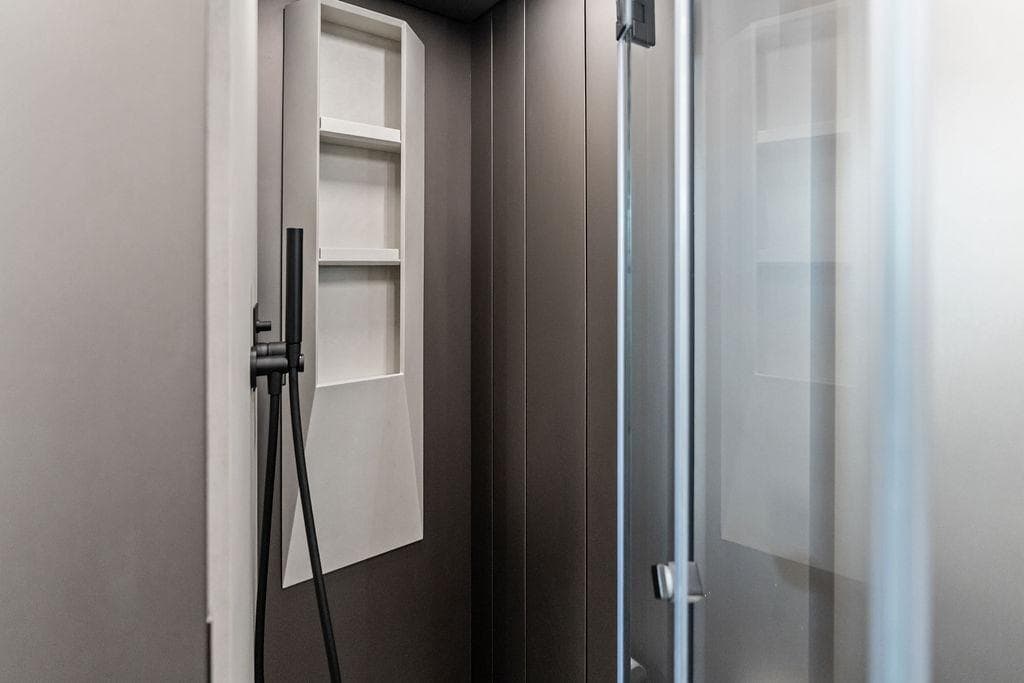 Modern shower interior in 2025 Pershing GTX 80 yacht, featuring sleek design and shelving.