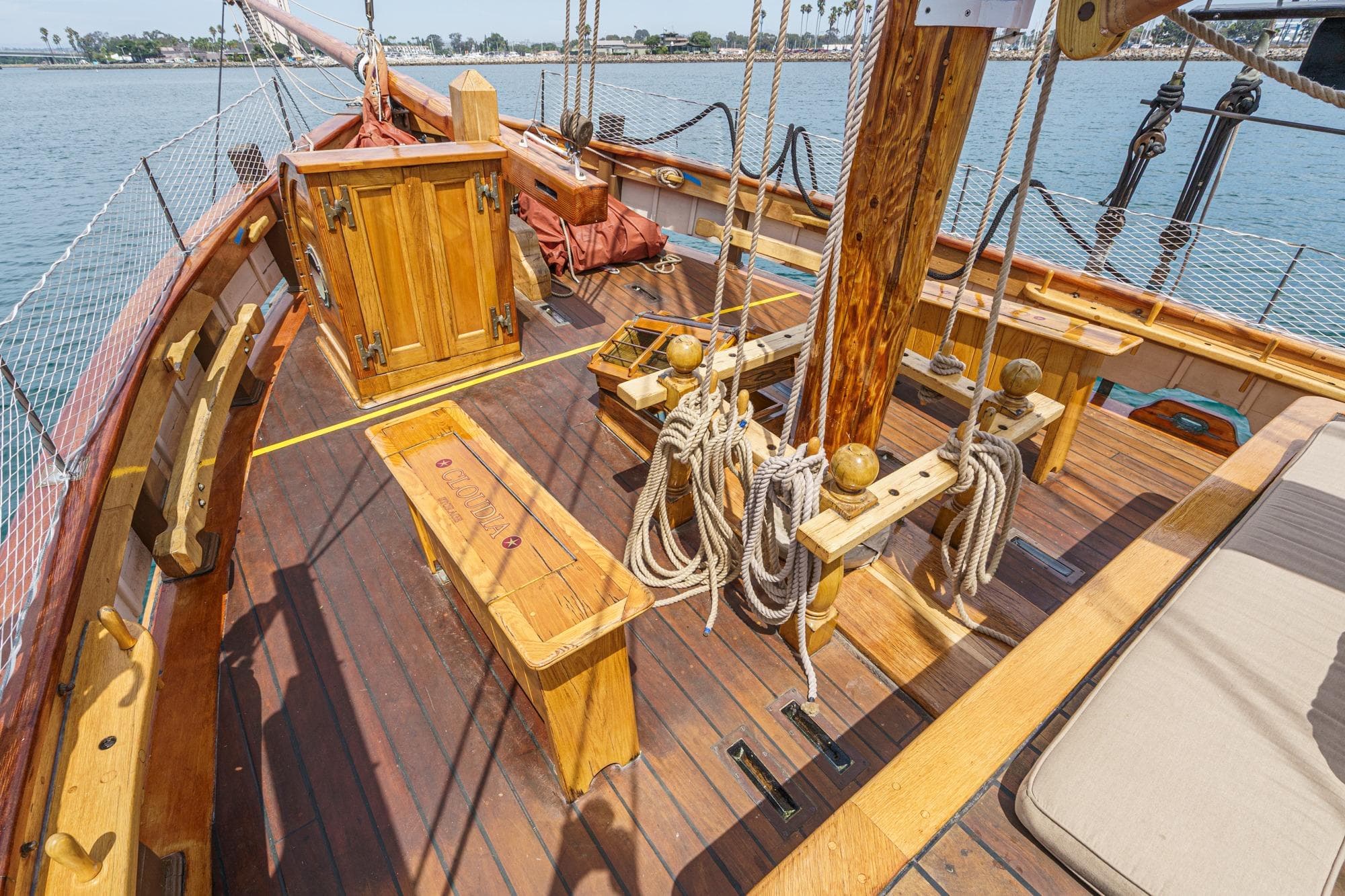Wooden deck of 1938 Norwegian Double Ended Ketch with ropes and seating.