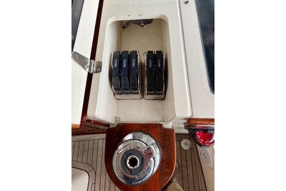 Control panel of a 2014 Leonardo Yachts Eagle 44 sailboat, featuring switches and a winch handle.