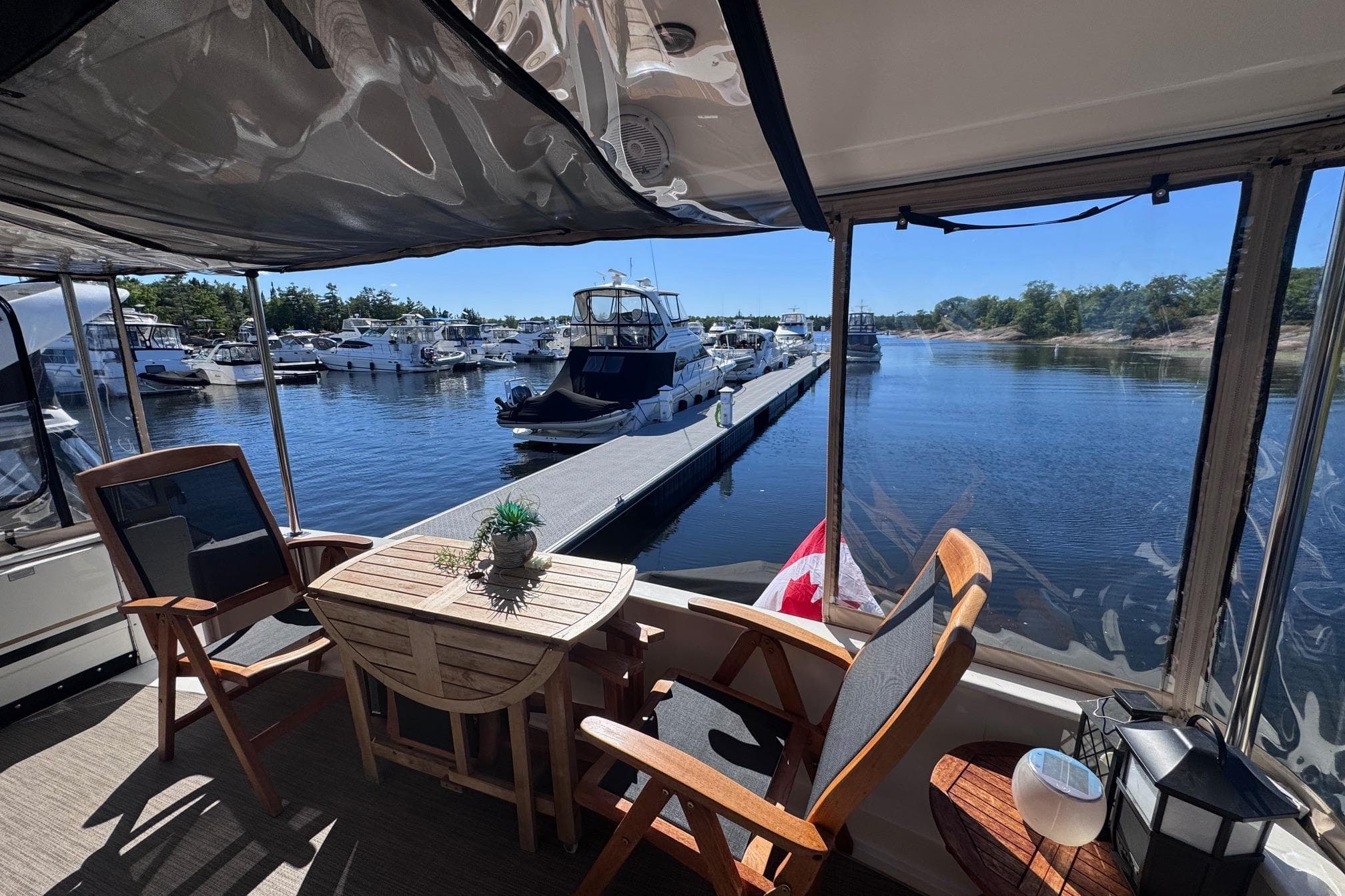 2000 Sea Ray 380 Aft Cabin yacht interior with marina view, featuring wooden furniture and Canadian flag.