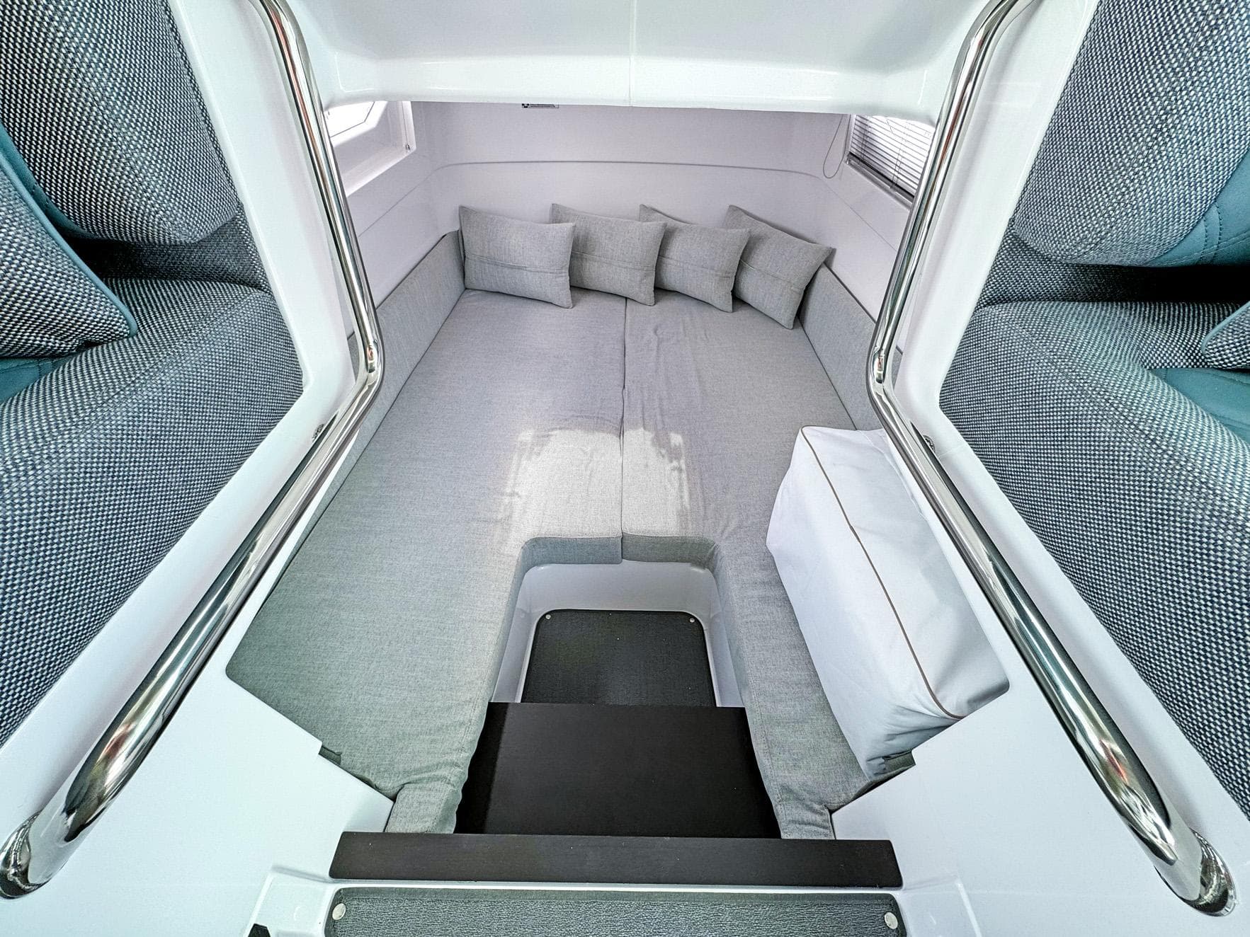2024 Axopar 37XC CROSS CABIN interior with cozy gray seating and cushions.