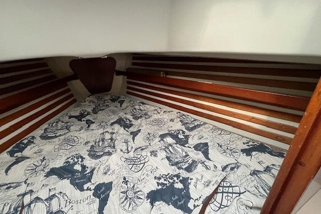 Cozy cabin interior of 1981 Niagara 31 sailboat with nautical-themed bedding.