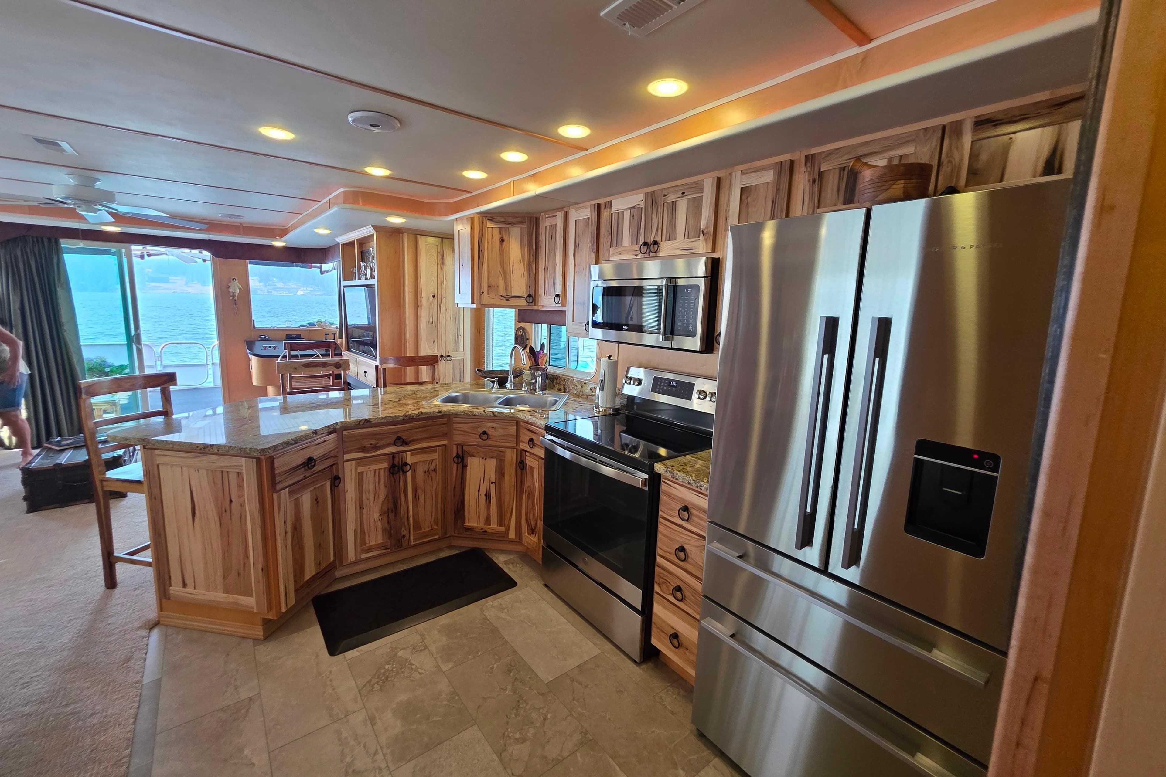 Luxurious kitchen in 2015 Sailabration 64 houseboat with modern appliances and wood cabinetry.