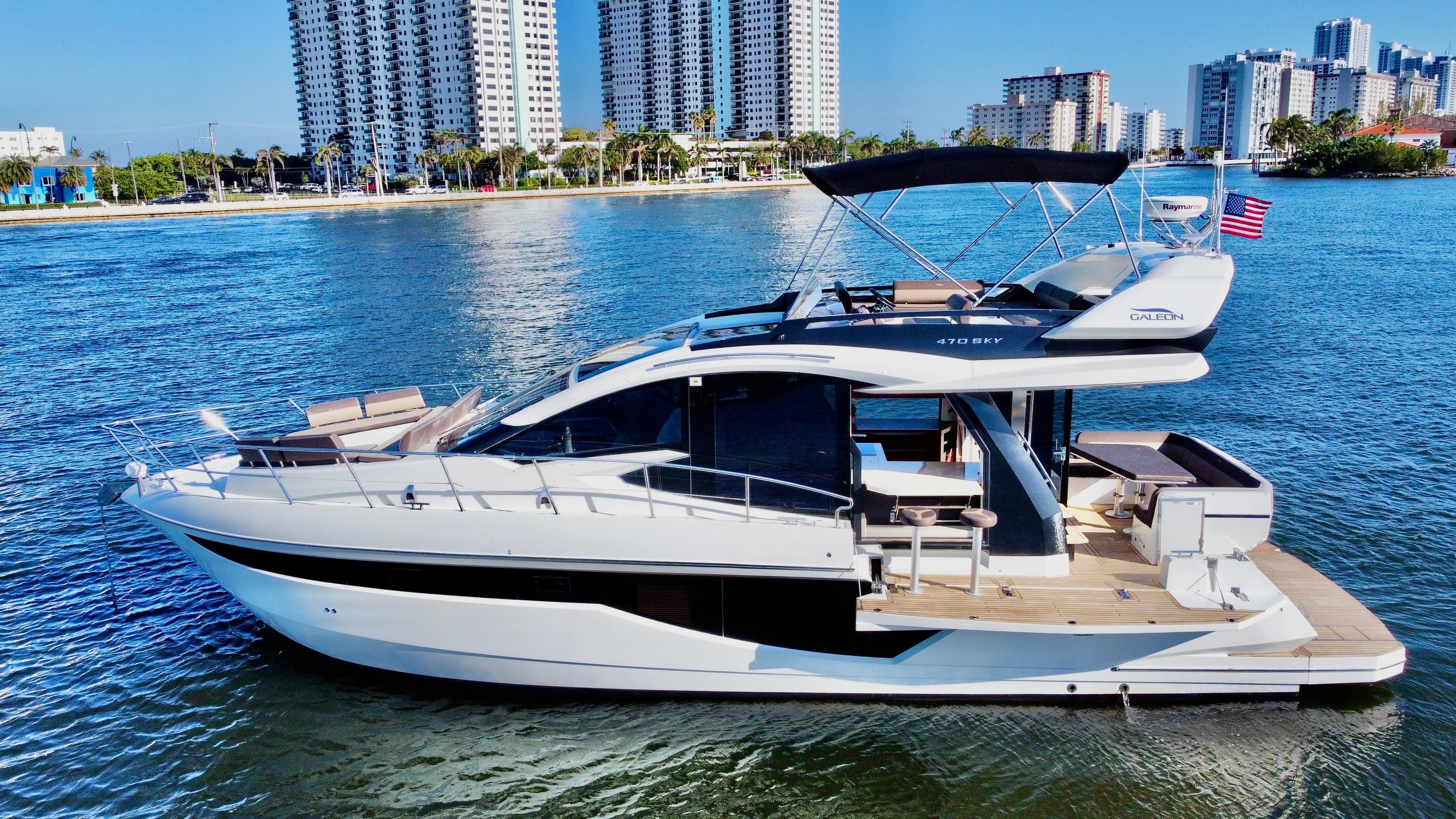 2022 Galeon 470 Sky yacht cruising near city waterfront.