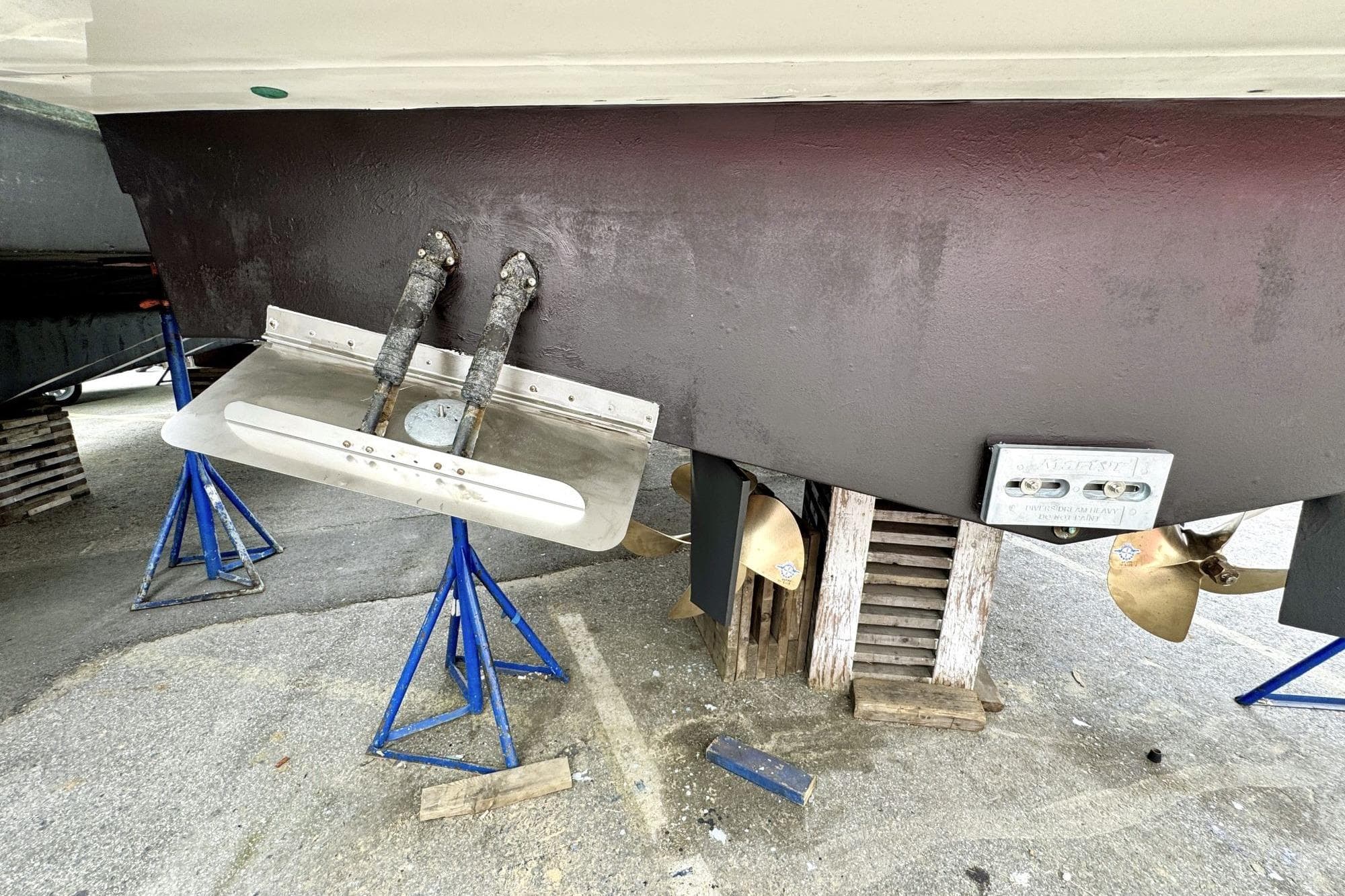 2016 Carver C40 boat hull with propellers and trim tabs on stands.