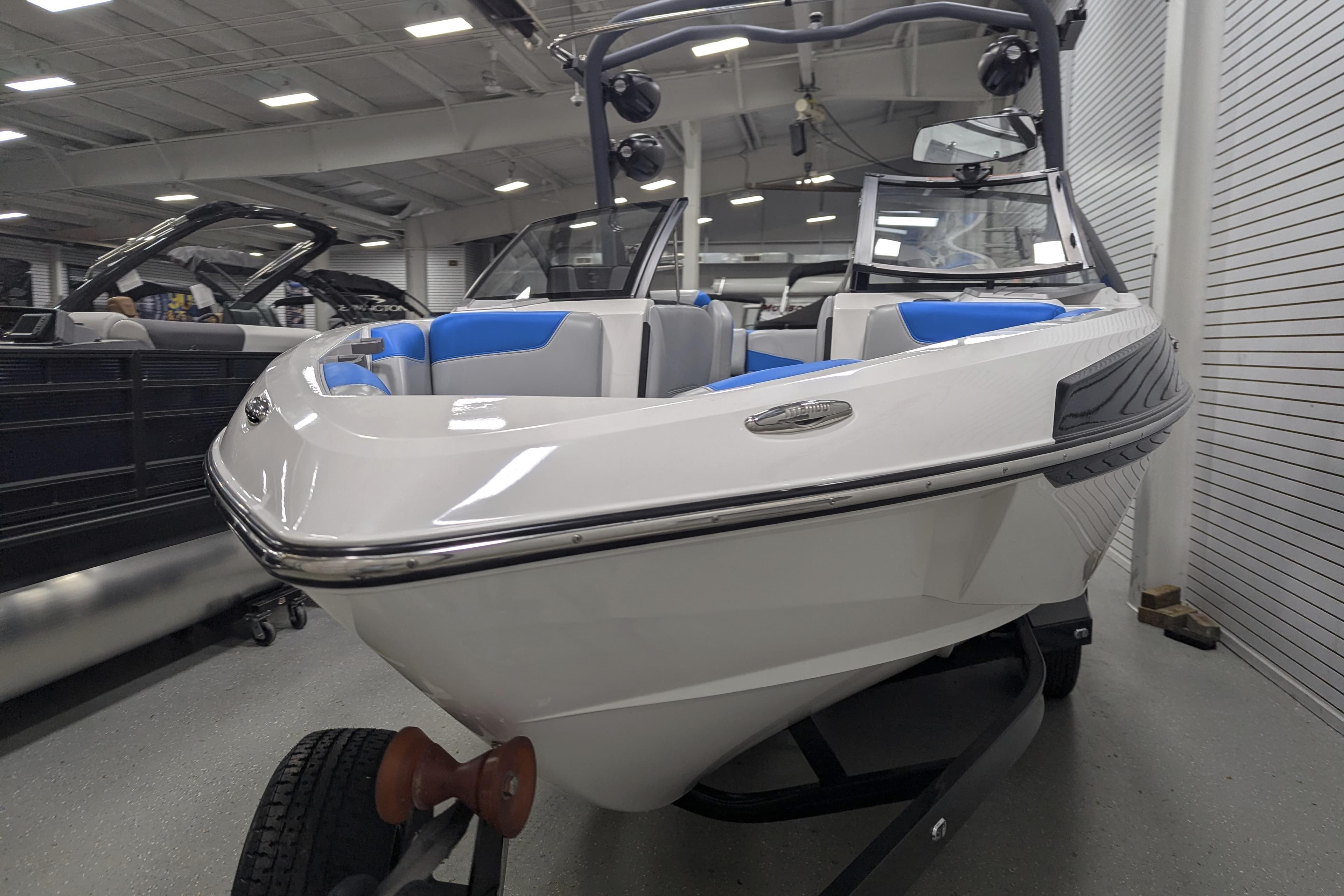 2022 Malibu Wakesetter 22 LSV boat in showroom, featuring sleek design and blue interior.