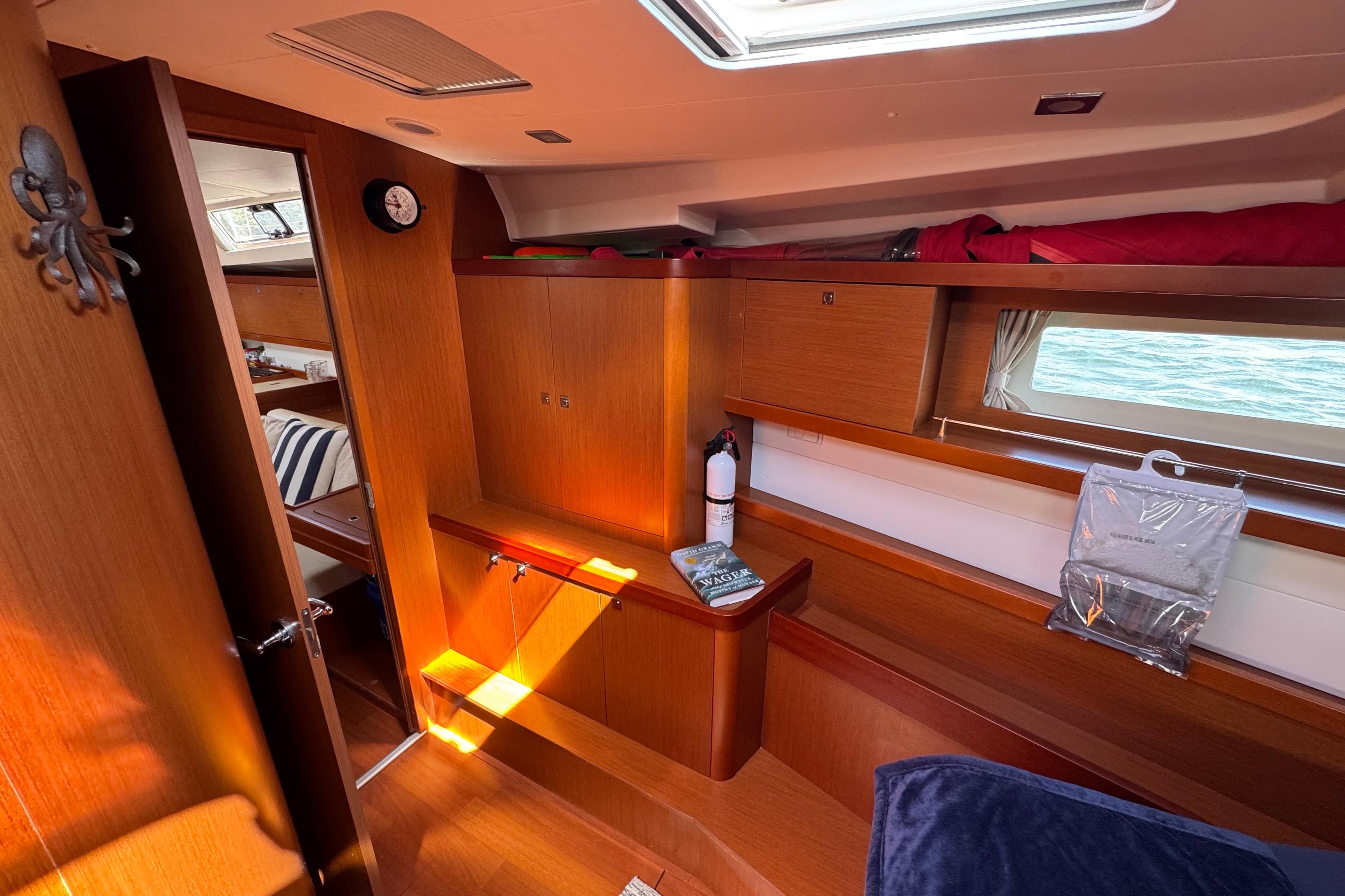 Interior of 2013 Beneteau Oceanis 45 yacht, featuring wooden cabinetry and nautical decor.