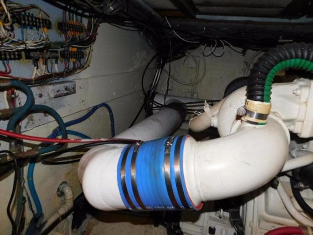 Engine room of a 1976 Bertram 42 Convertible with visible pipes and wiring.