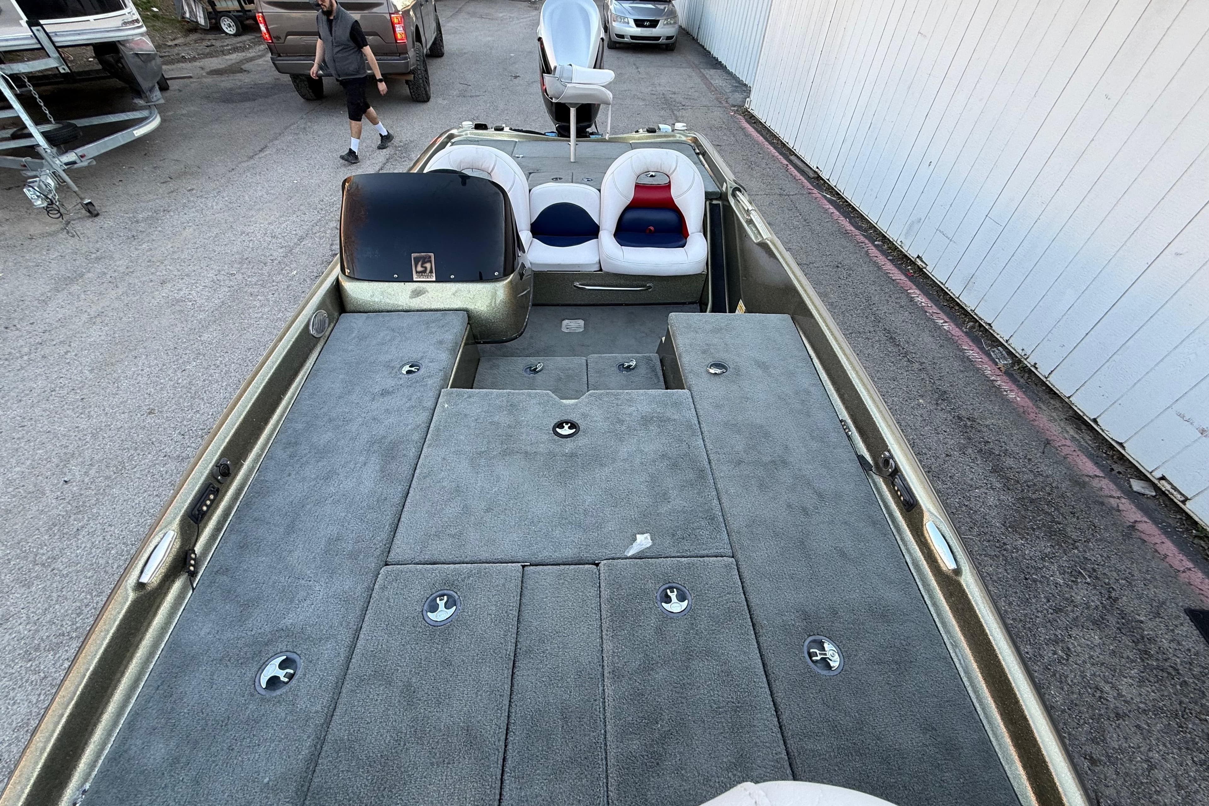 2005 Bass Cat Puma boat with spacious deck and seating, parked outdoors.