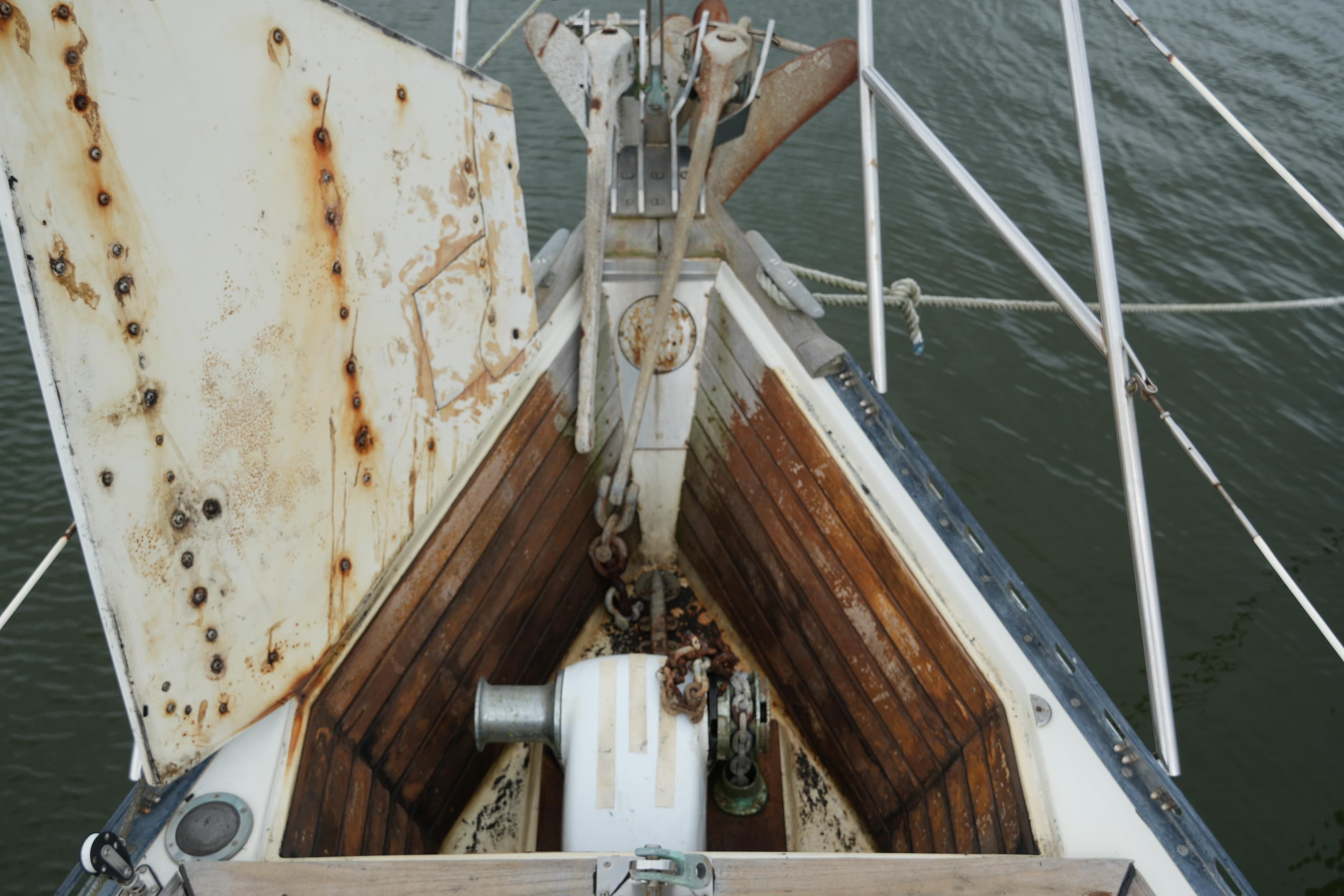 Bow of 1980 Lafitte 44 Cutter sailboat with anchor and winch.