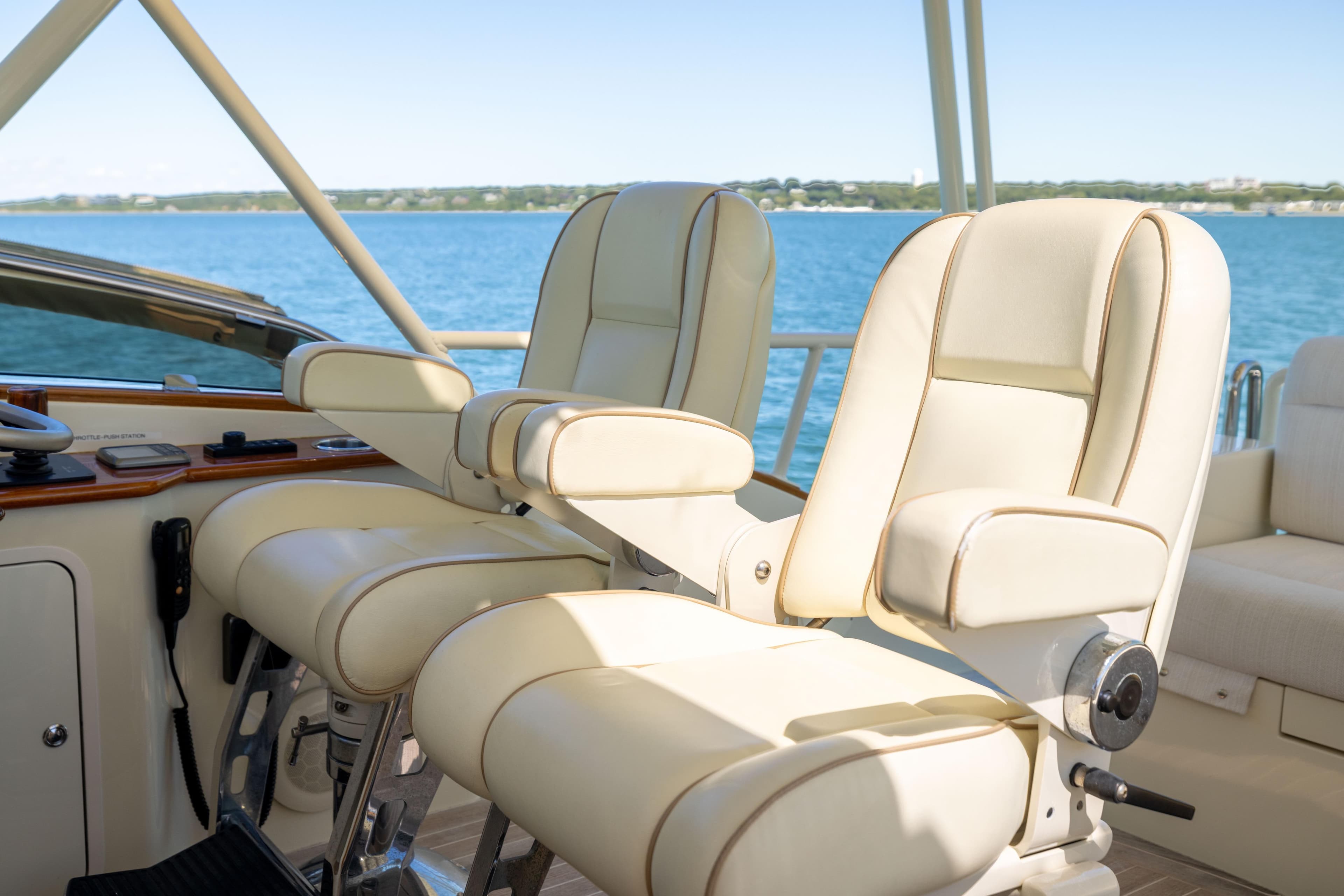 Luxurious helm seats on 2014 Hinckley Talaria 48 Flybridge yacht, overlooking serene waters.