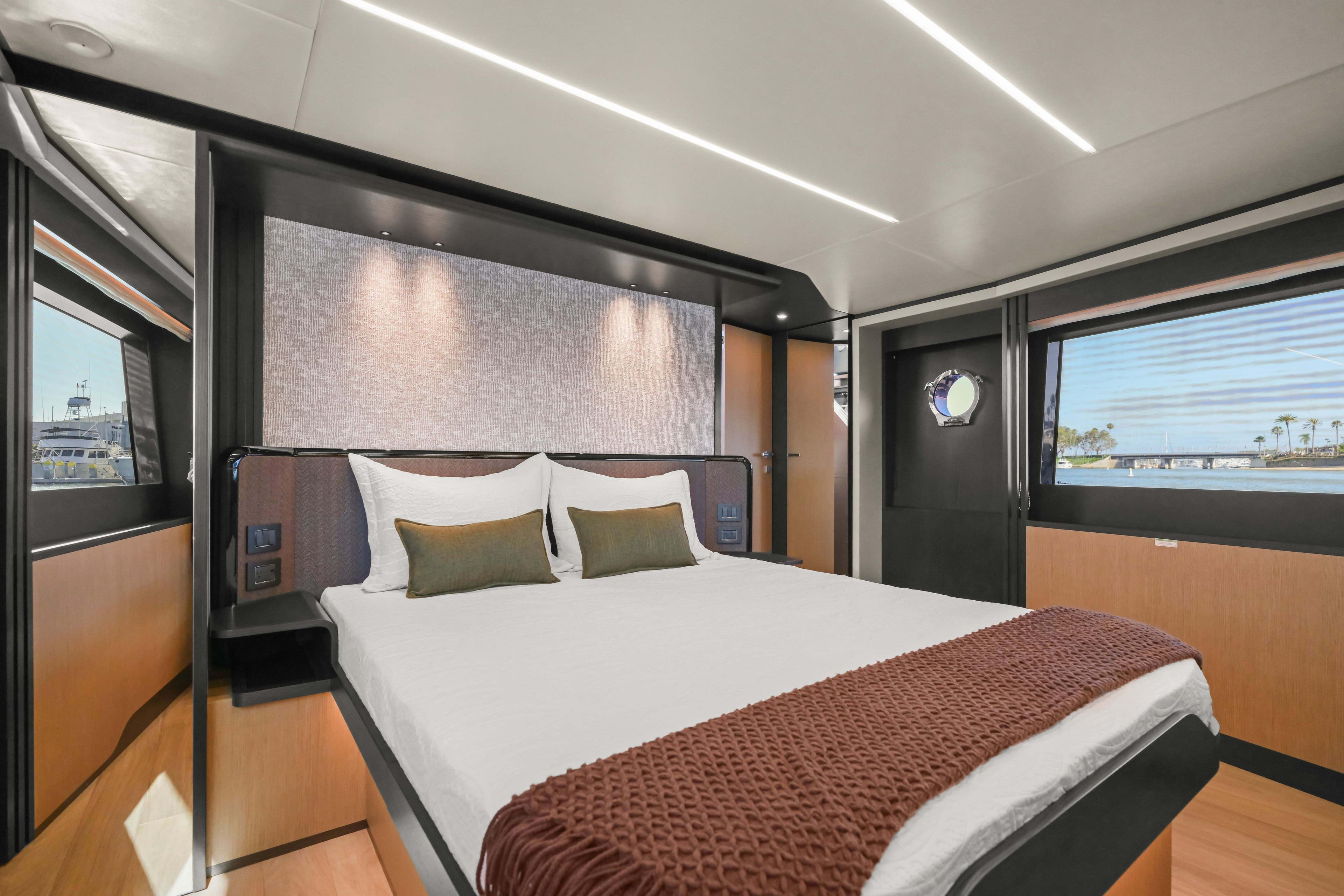 Luxurious bedroom interior of 2026 Absolute 52 Fly yacht with modern design and scenic views.