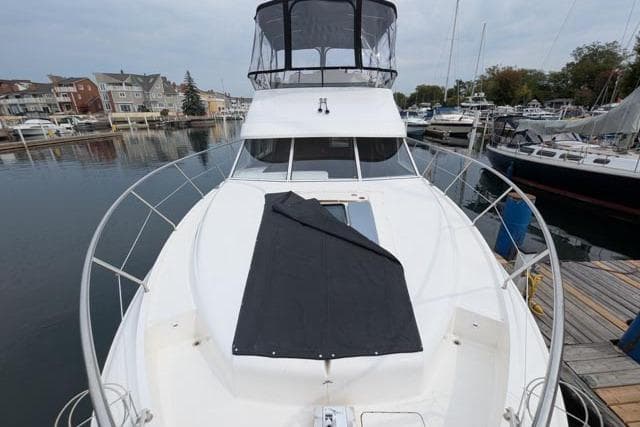 1998 Silverton 402 Motor Yacht docked in a marina, featuring a spacious deck and covered flybridge.