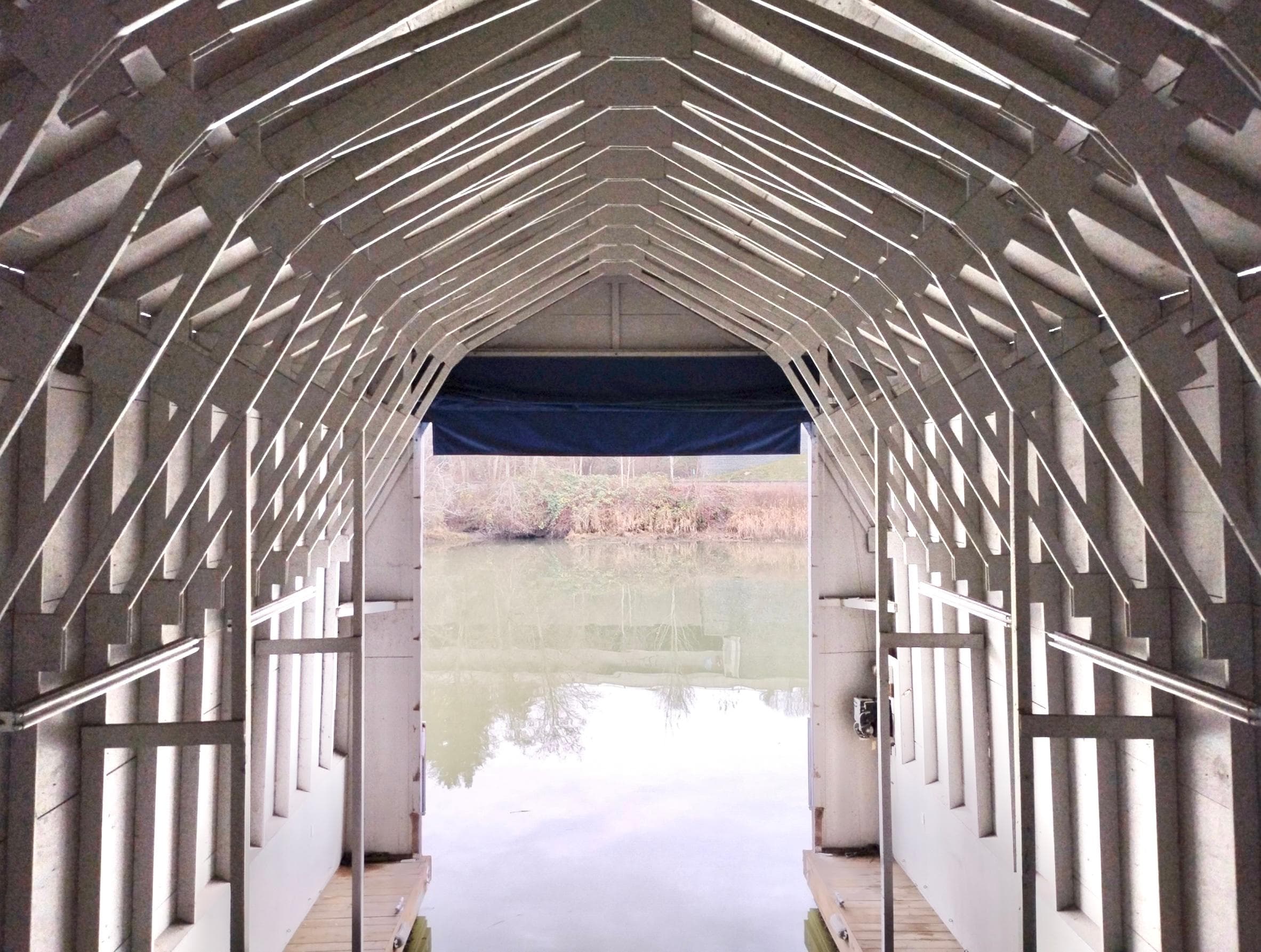 Interior view of a custom boathouse, 2013, overlooking a serene lake.