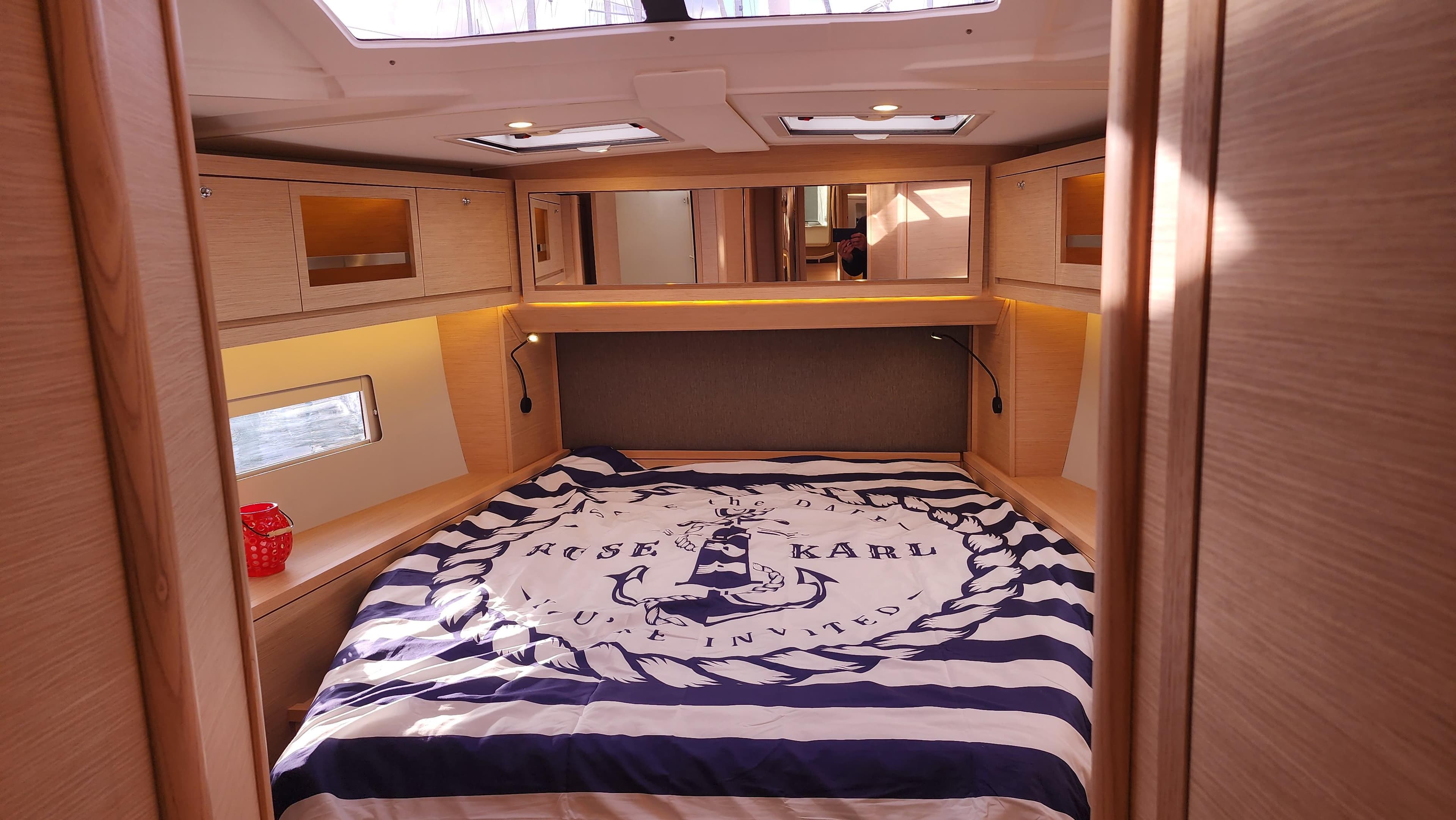 Luxurious cabin interior of 2023 Dufour 470 yacht with nautical-themed bedding.