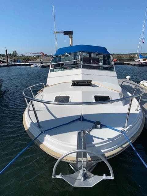 1989 Limestone 24 Express Cruiser docked in a marina, front view.