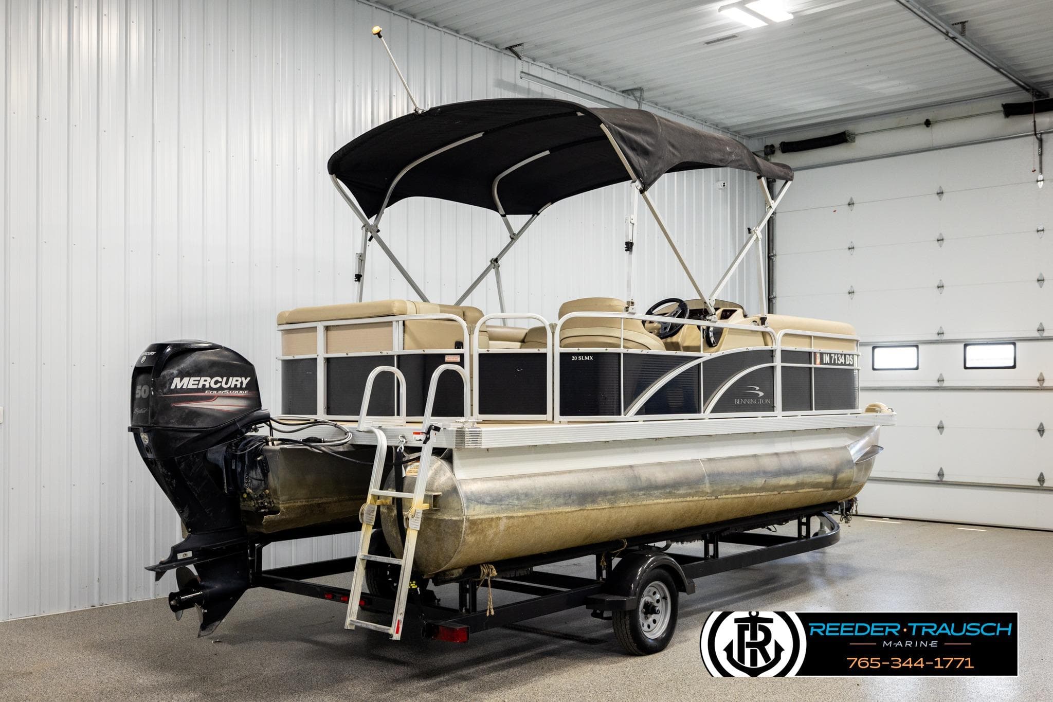 2013 Bennington 20 SLMX pontoon boat with Mercury outboard motor in a garage.