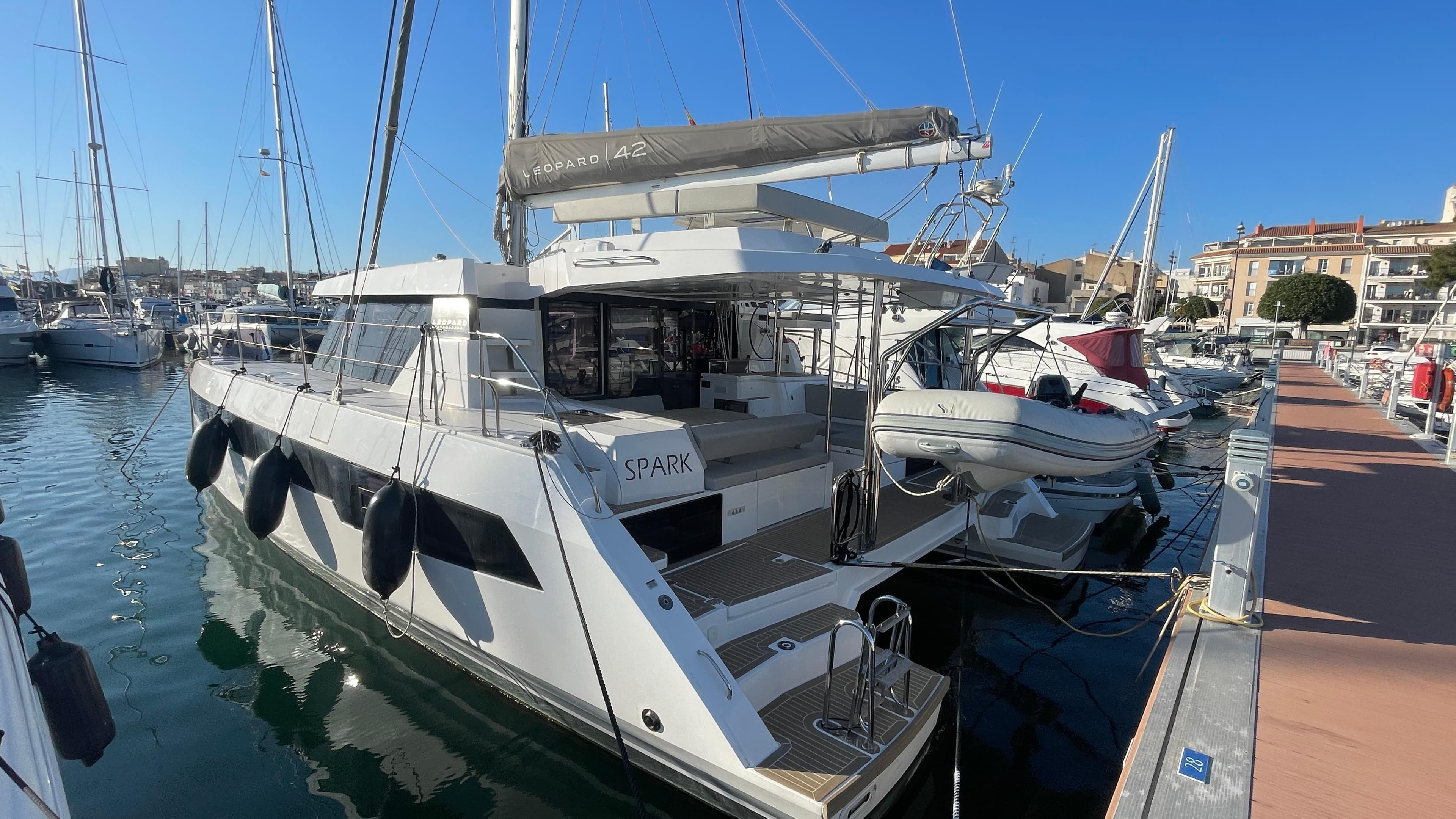 2022 Leopard 42 catamaran docked in marina, sunny day, clear blue sky.