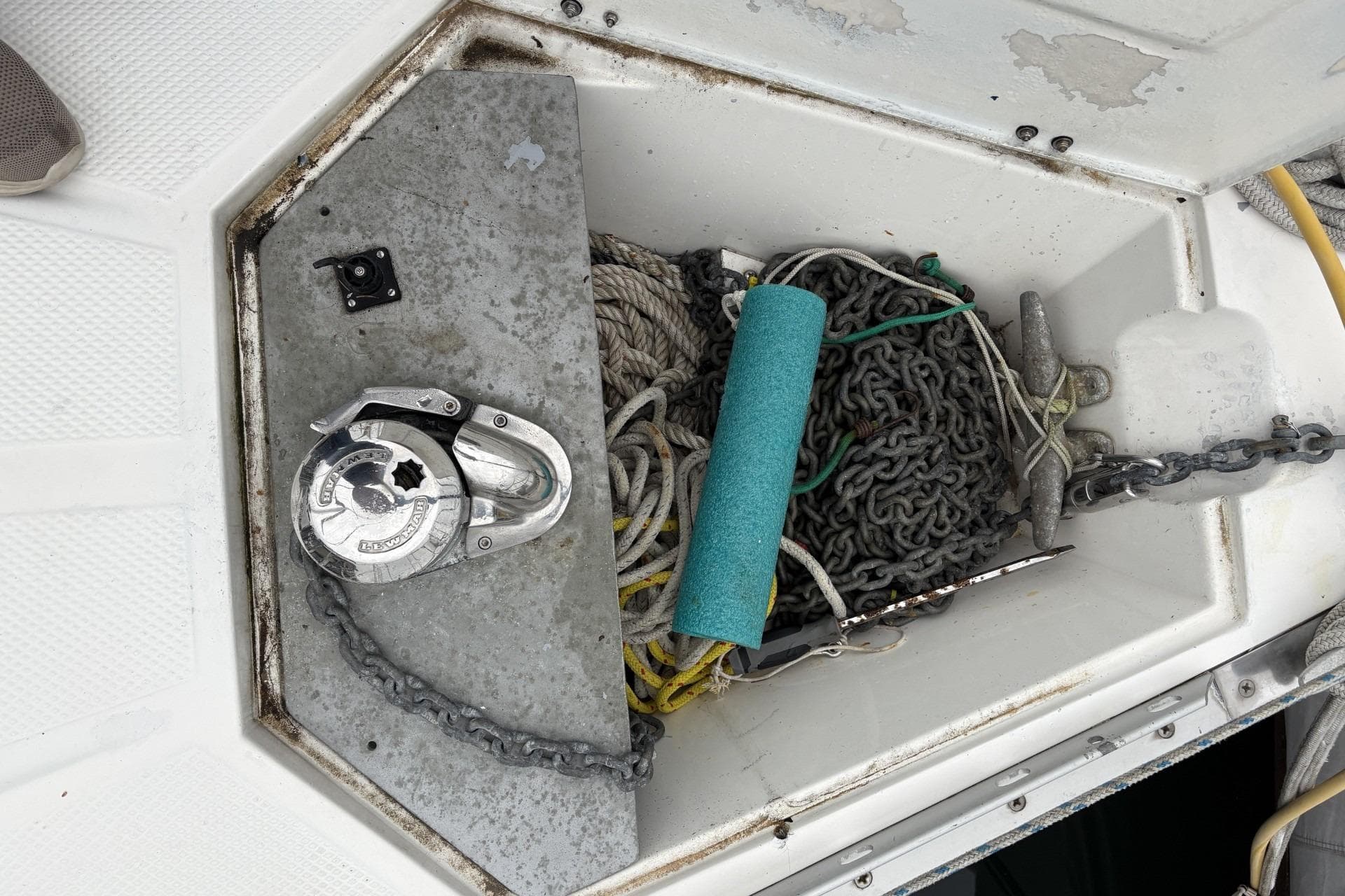 Anchor locker of 1984 Hunter 34 sailboat with chain, rope, and windlass.