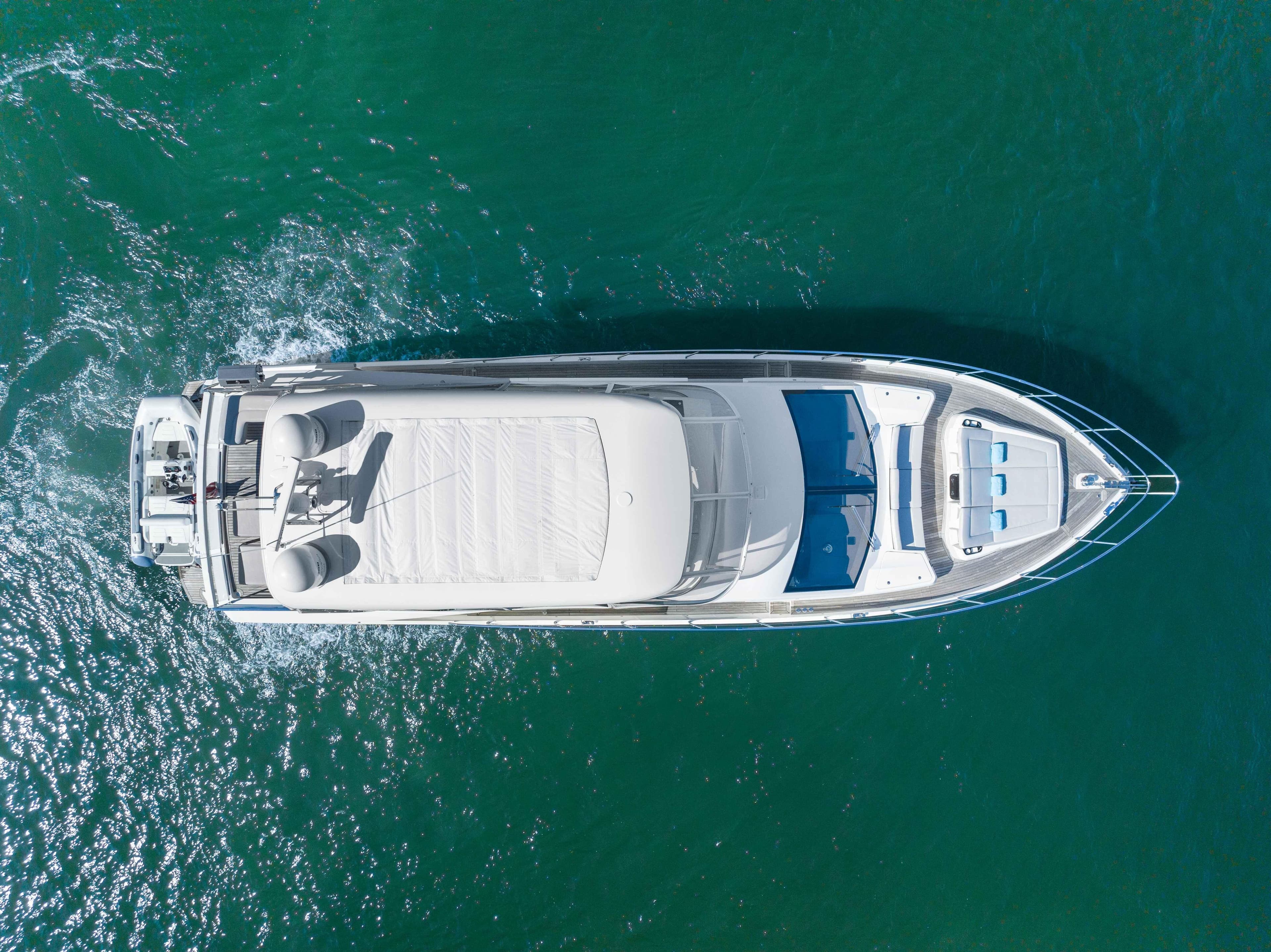 Aerial view of 2015 Absolute 64 FLY yacht cruising on clear blue water.