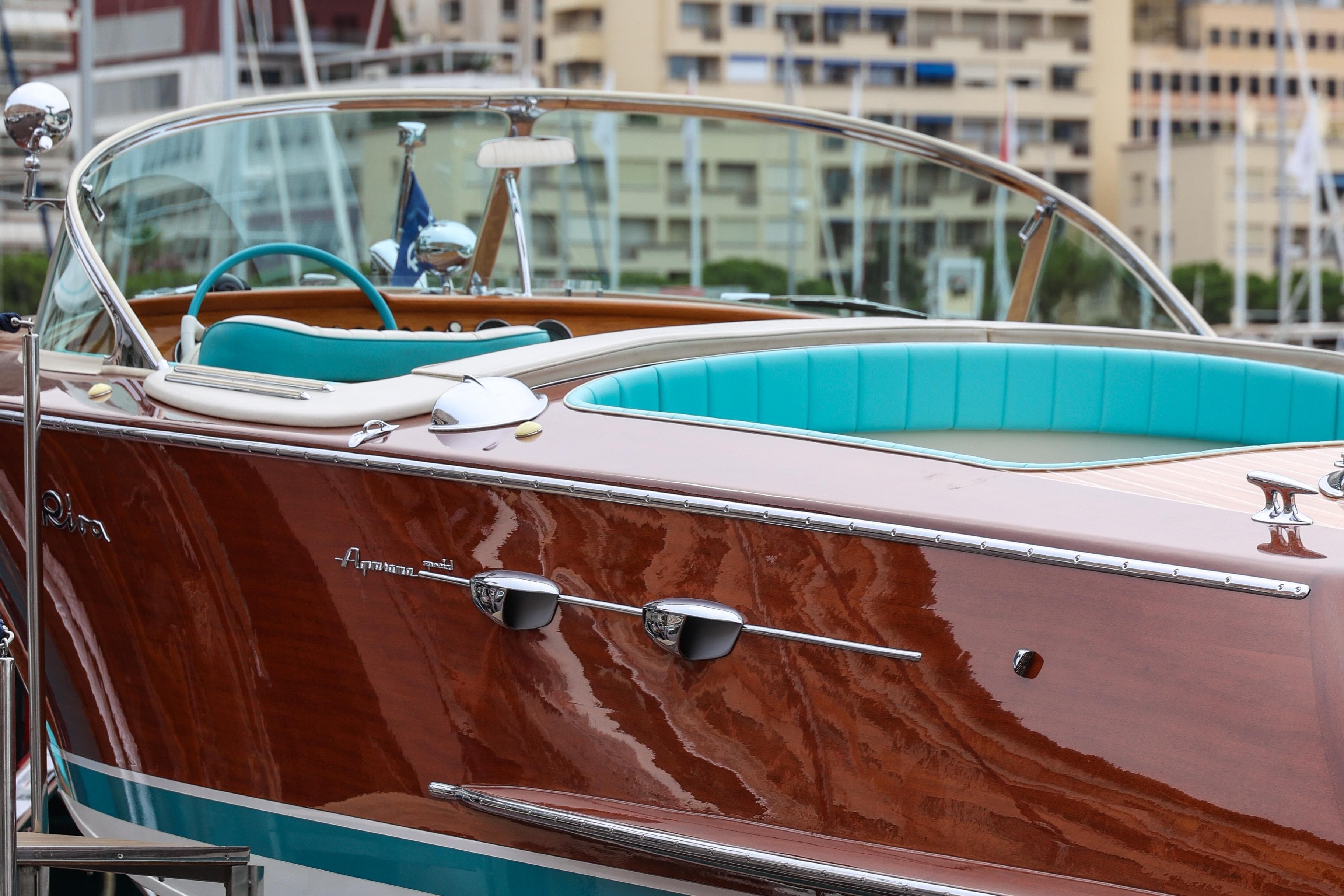 1974 Riva Aquarama Special boat with turquoise interior, docked in a marina.