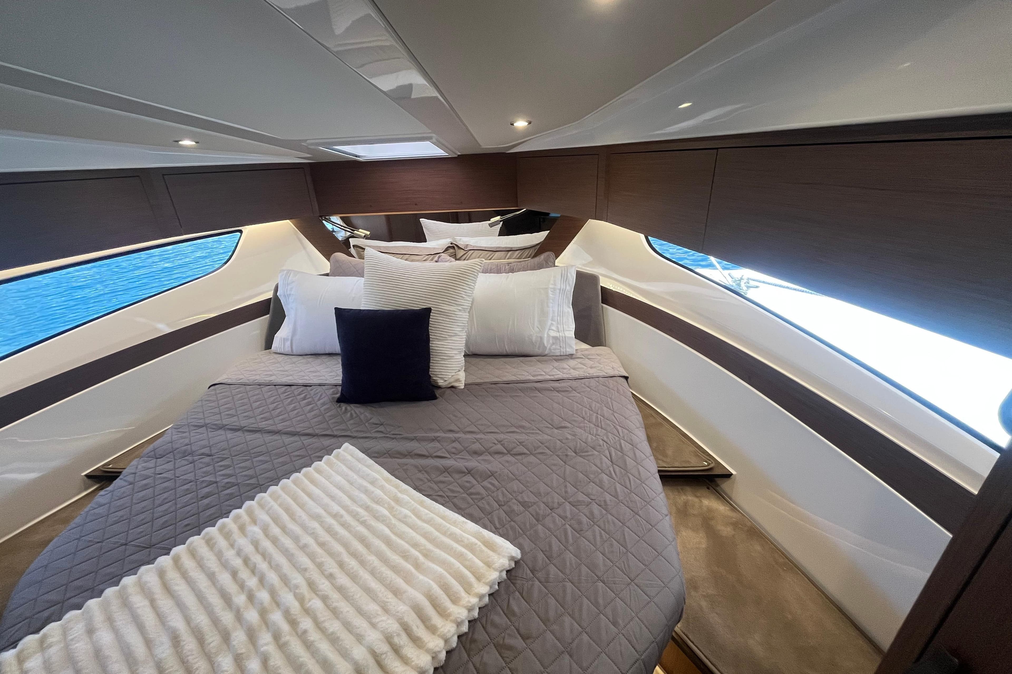 Luxurious cabin interior of 2026 Beneteau Antares 11 Coupe with elegant bedding and modern design.