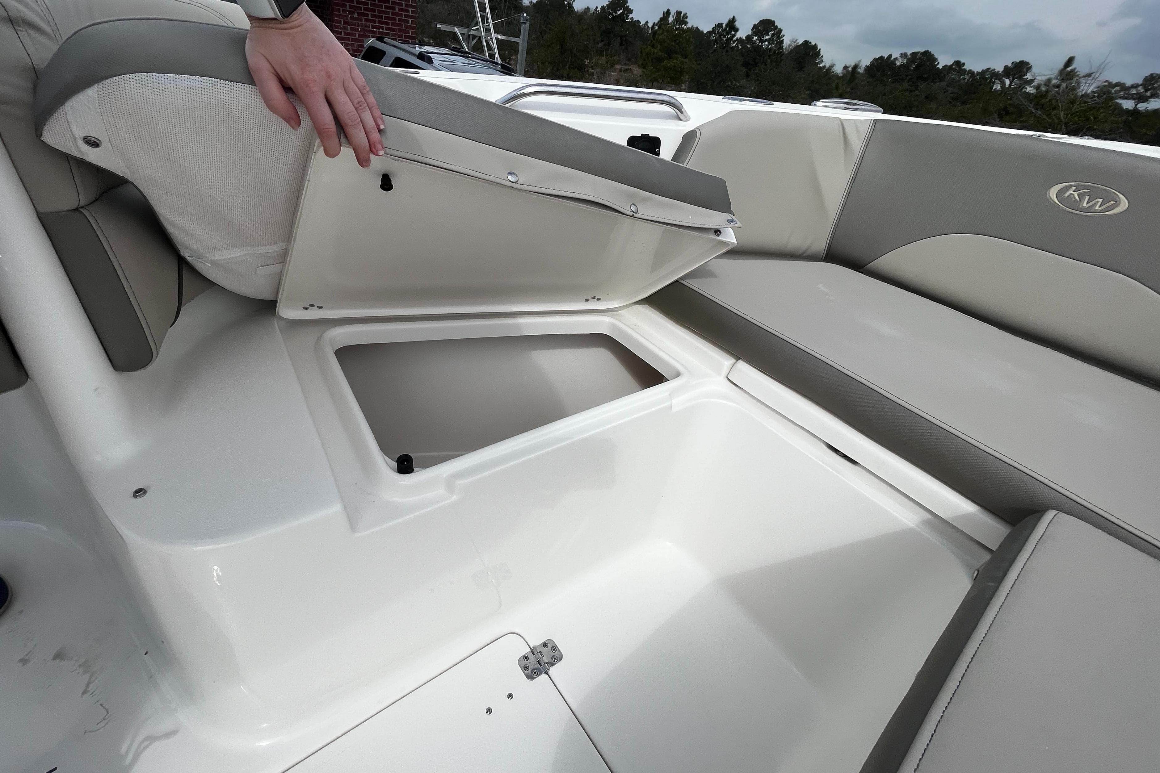2025 Key West 263 FS boat with open storage compartment and seating.