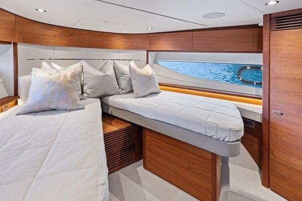 Luxurious cabin interior of 2020 Princess V55 yacht with twin beds and elegant wood finish.