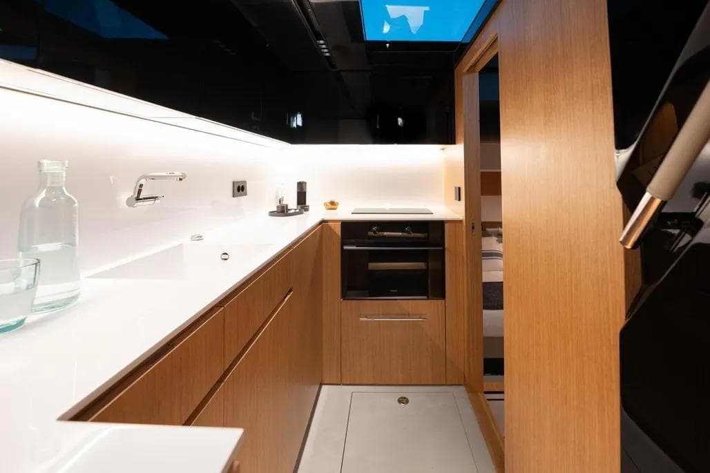 Modern kitchen interior of 2026 De Antonio Yachts D60, featuring sleek wood cabinetry and minimalist design.