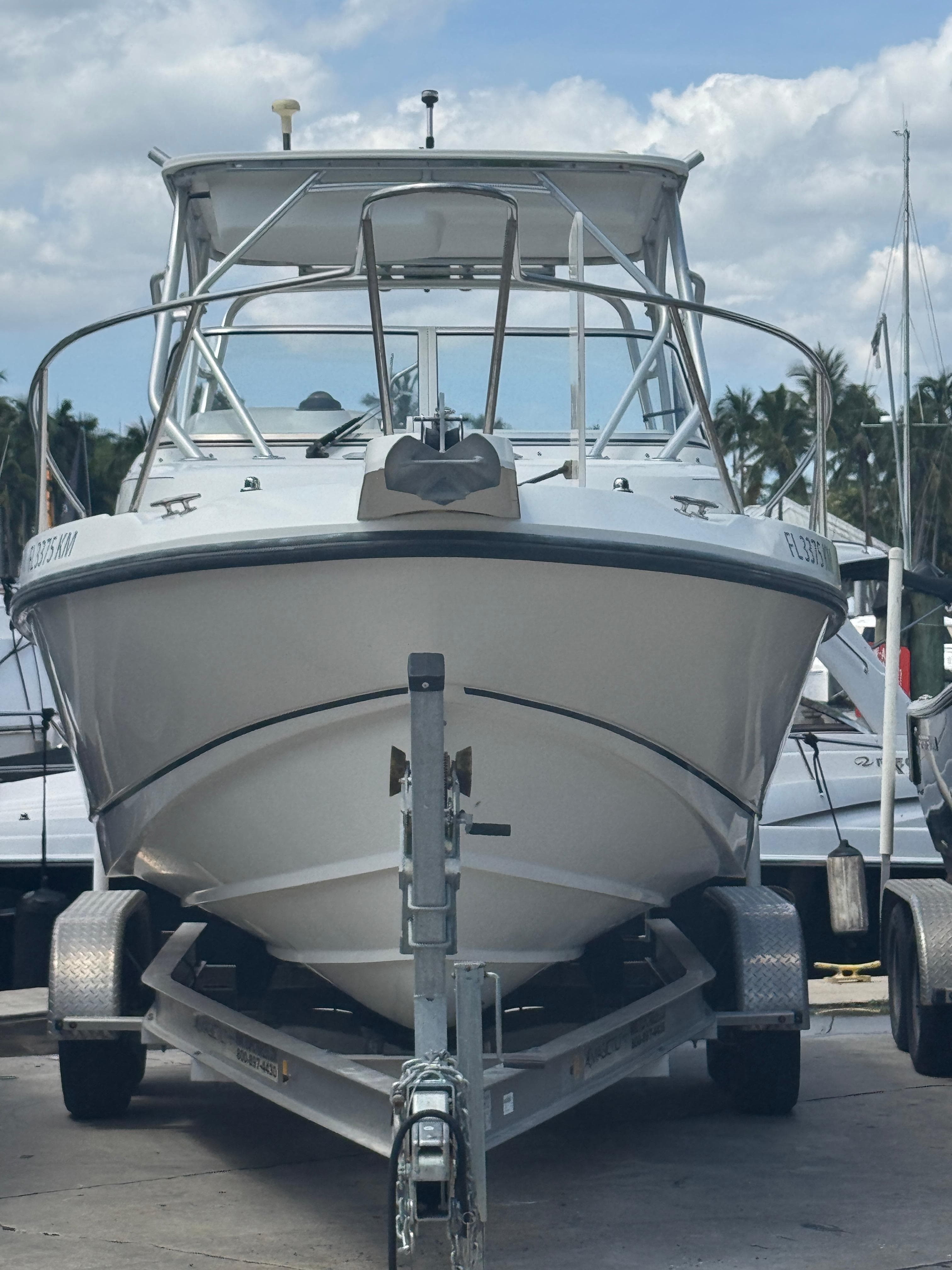 1999 Boston Whaler Conquest 23 boat on trailer, parked outdoors.