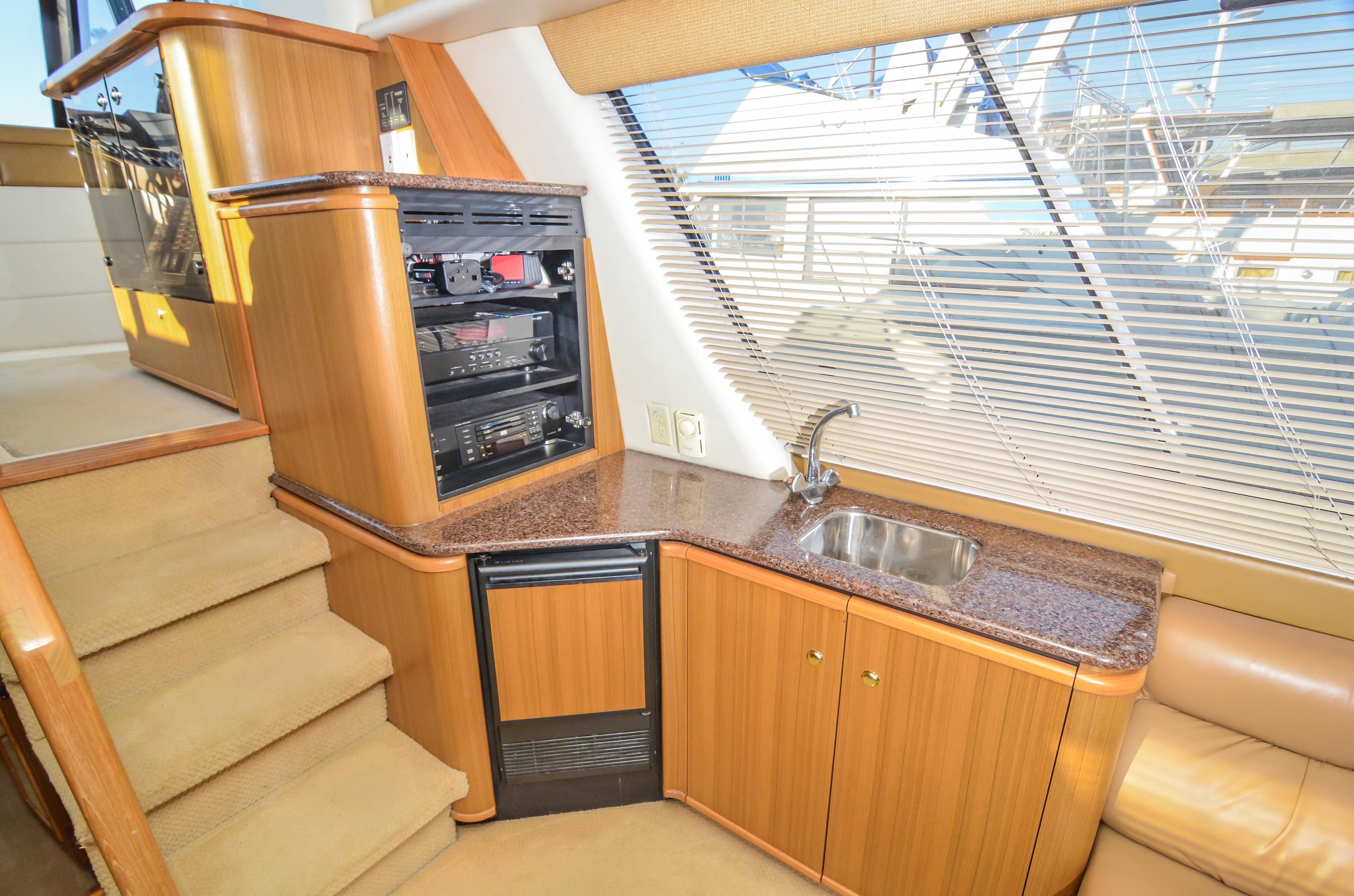 Luxurious interior of 2002 Bayliner 4788 Pilot House Motoryacht with kitchenette and stairs.