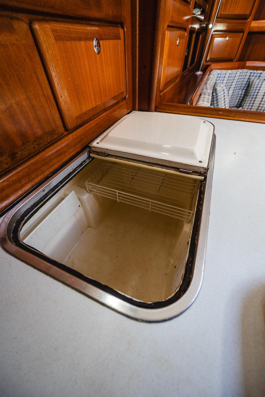 Bavaria 42 Ocean 1999 yacht interior with open storage compartment and wooden cabinetry.