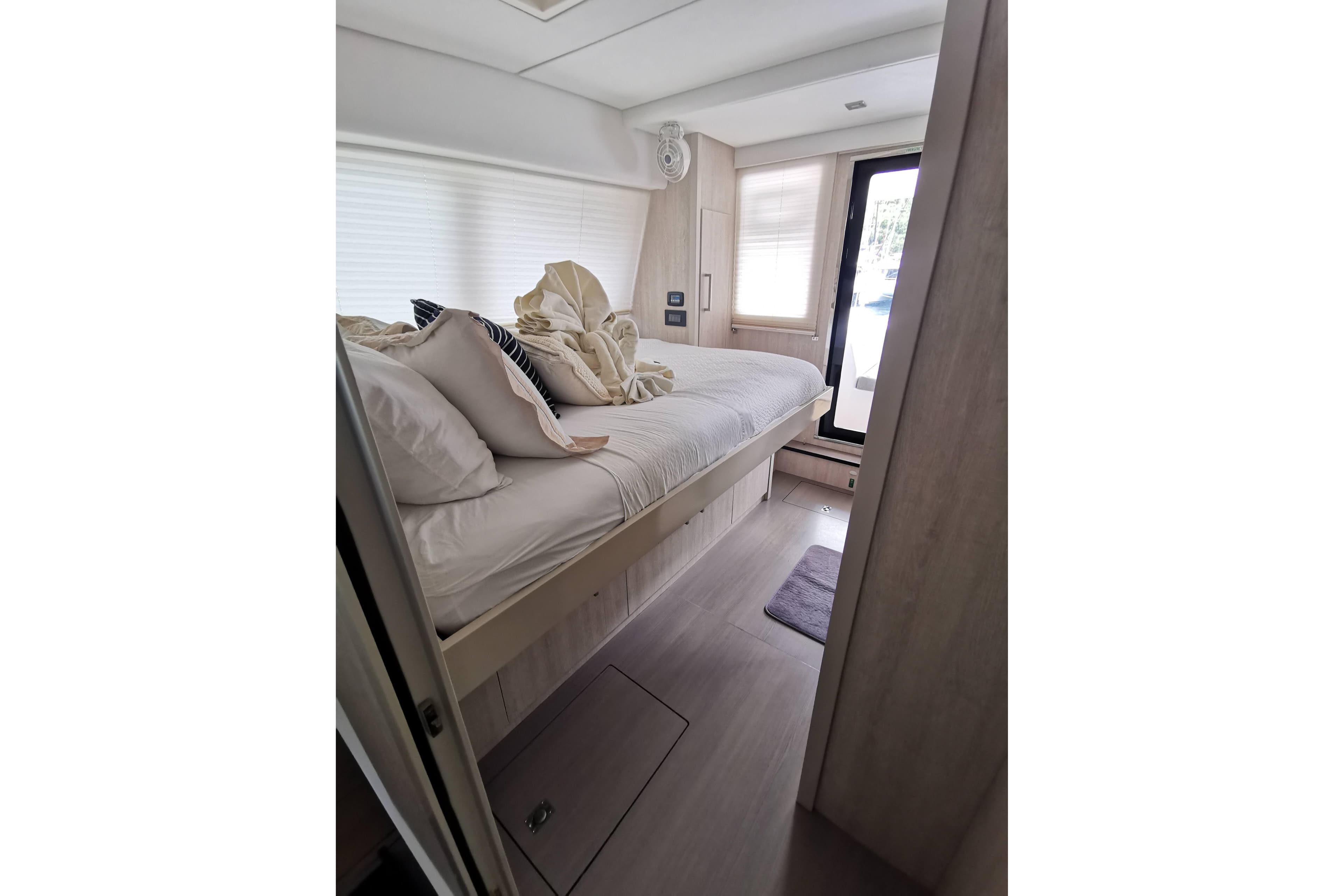 Luxurious bedroom interior of 2020 Leopard 58 yacht with modern decor and natural light.