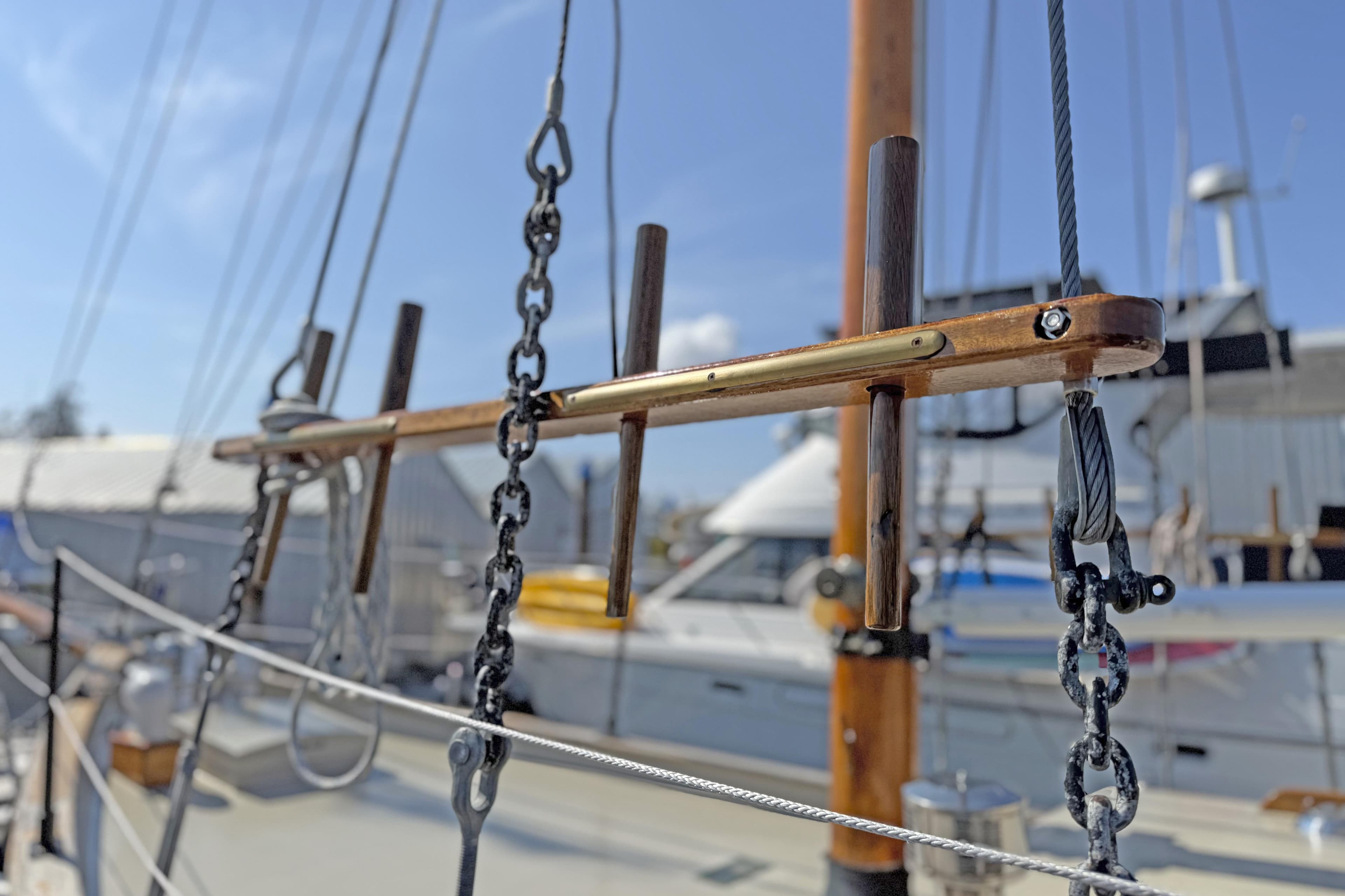 Close-up of rigging on a 1965 William Hand 45 sailboat, with marina background.