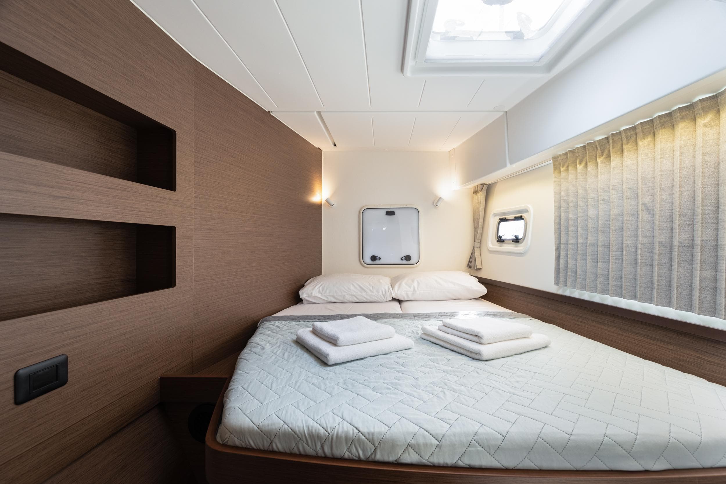 Luxurious cabin interior of 2020 Lagoon 42 catamaran with cozy bed and modern design.