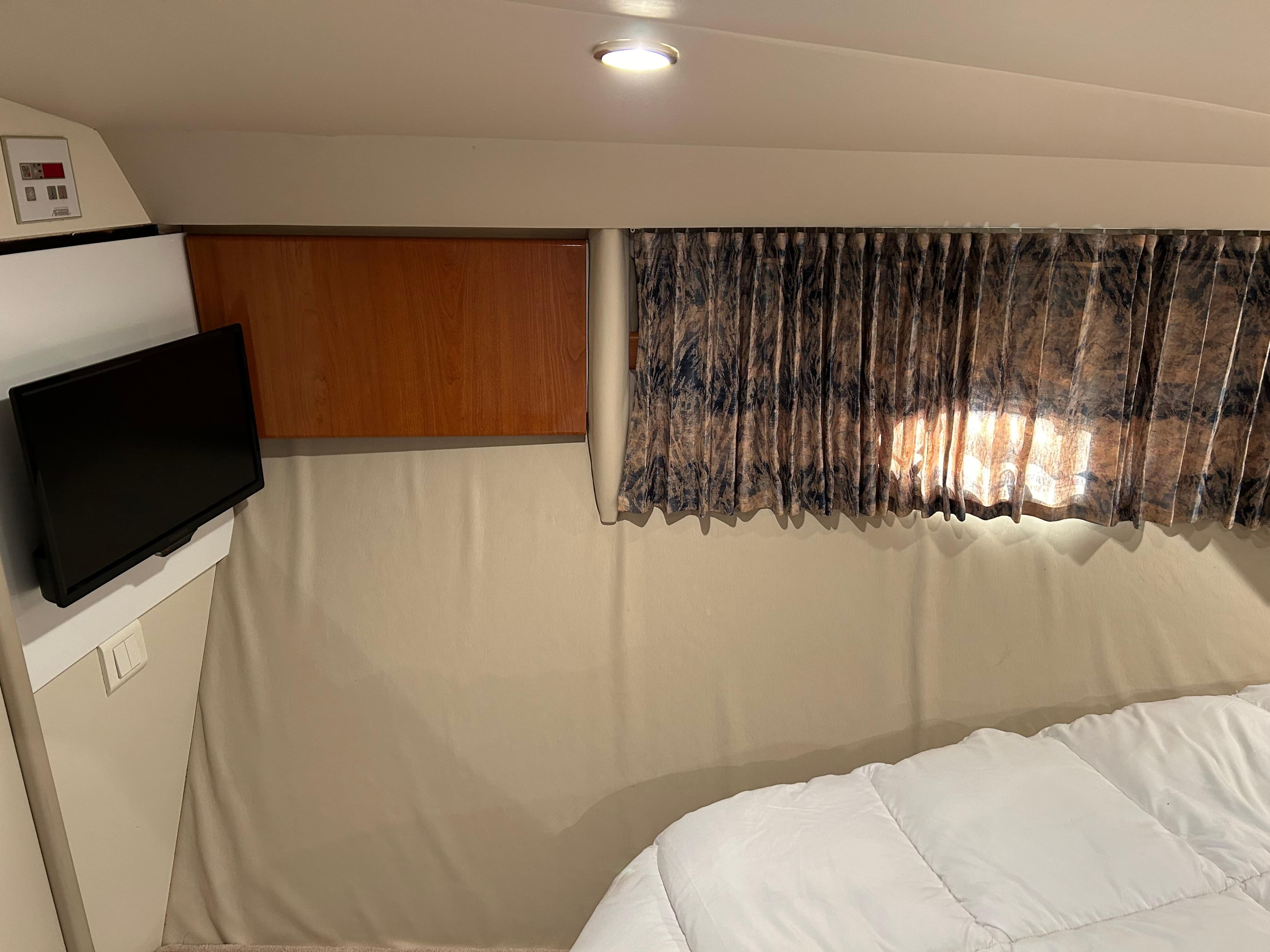 Interior of a 2000 Formula 41 Performance Cruiser with TV and curtains.