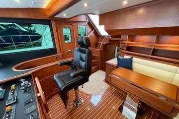 Luxurious interior of 2024 Northwest 55 yacht with leather chair and wooden furnishings.