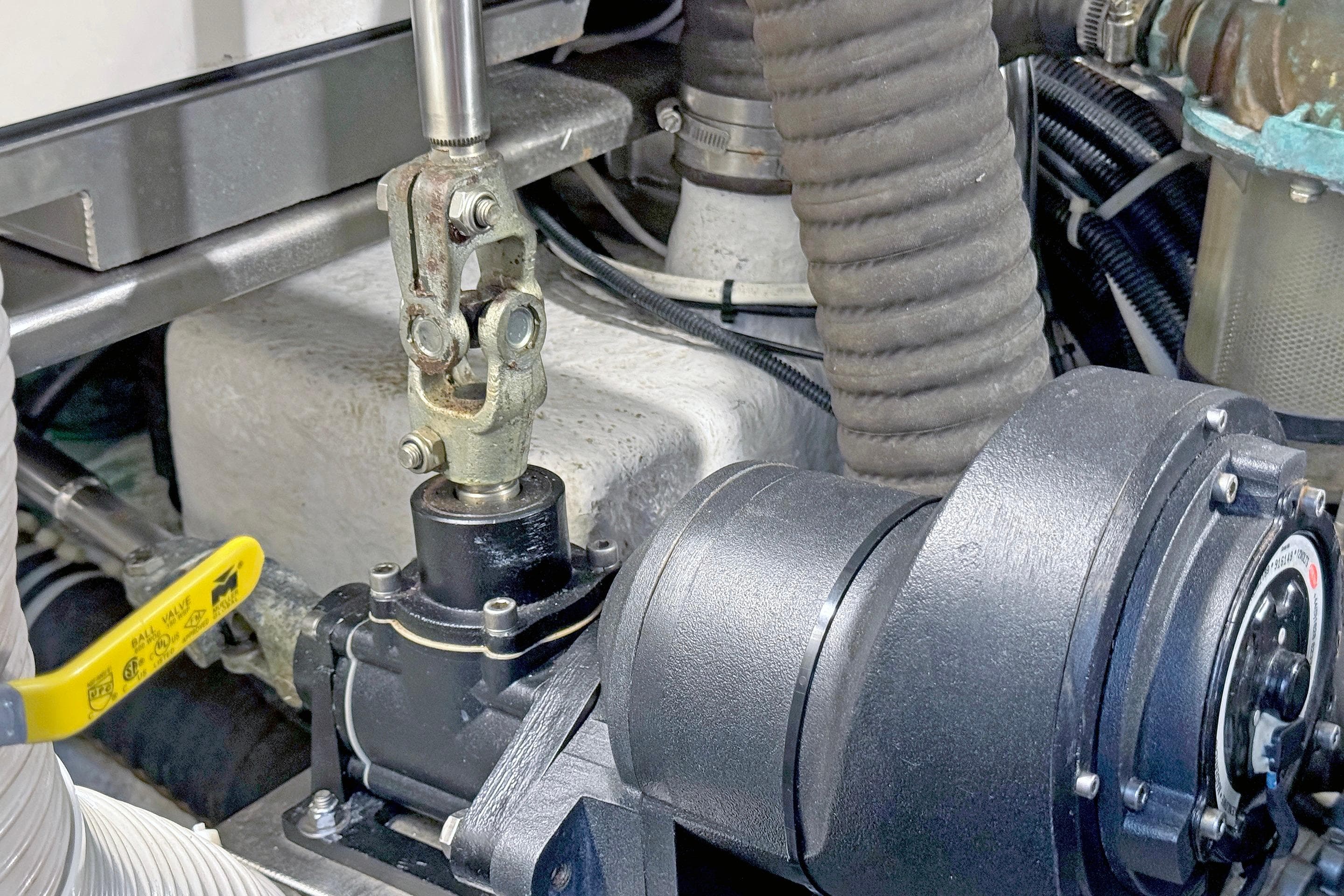 Engine compartment of a 2012 Hylas 49CC yacht, featuring mechanical components and hoses.