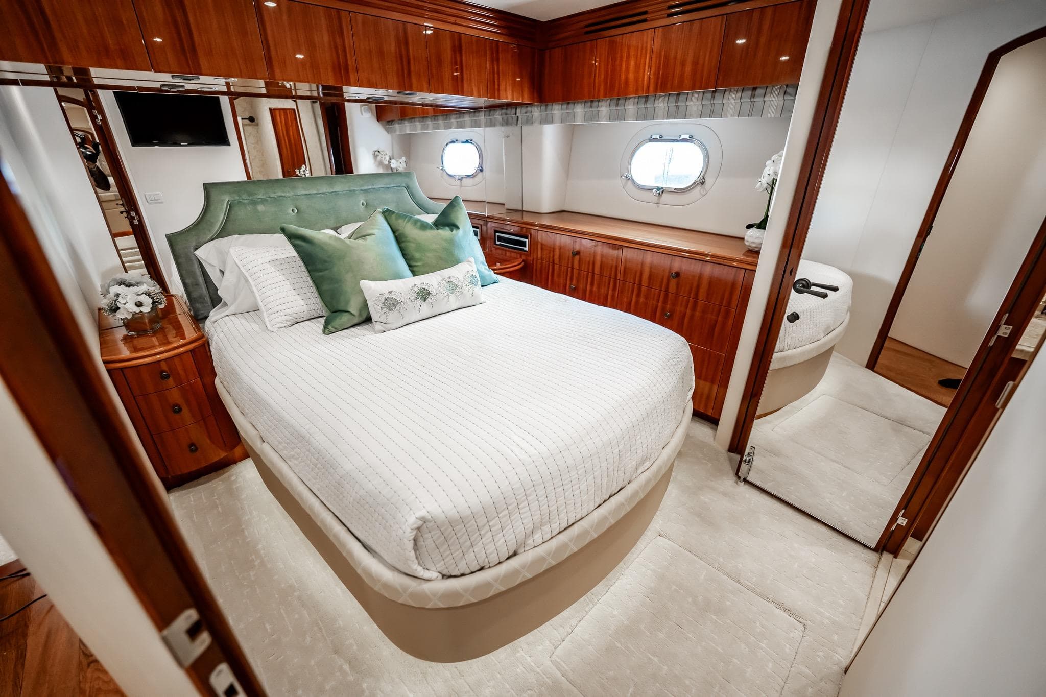 Luxurious bedroom interior of 2012 Hatteras 80 Motor Yacht with elegant wood finishes.