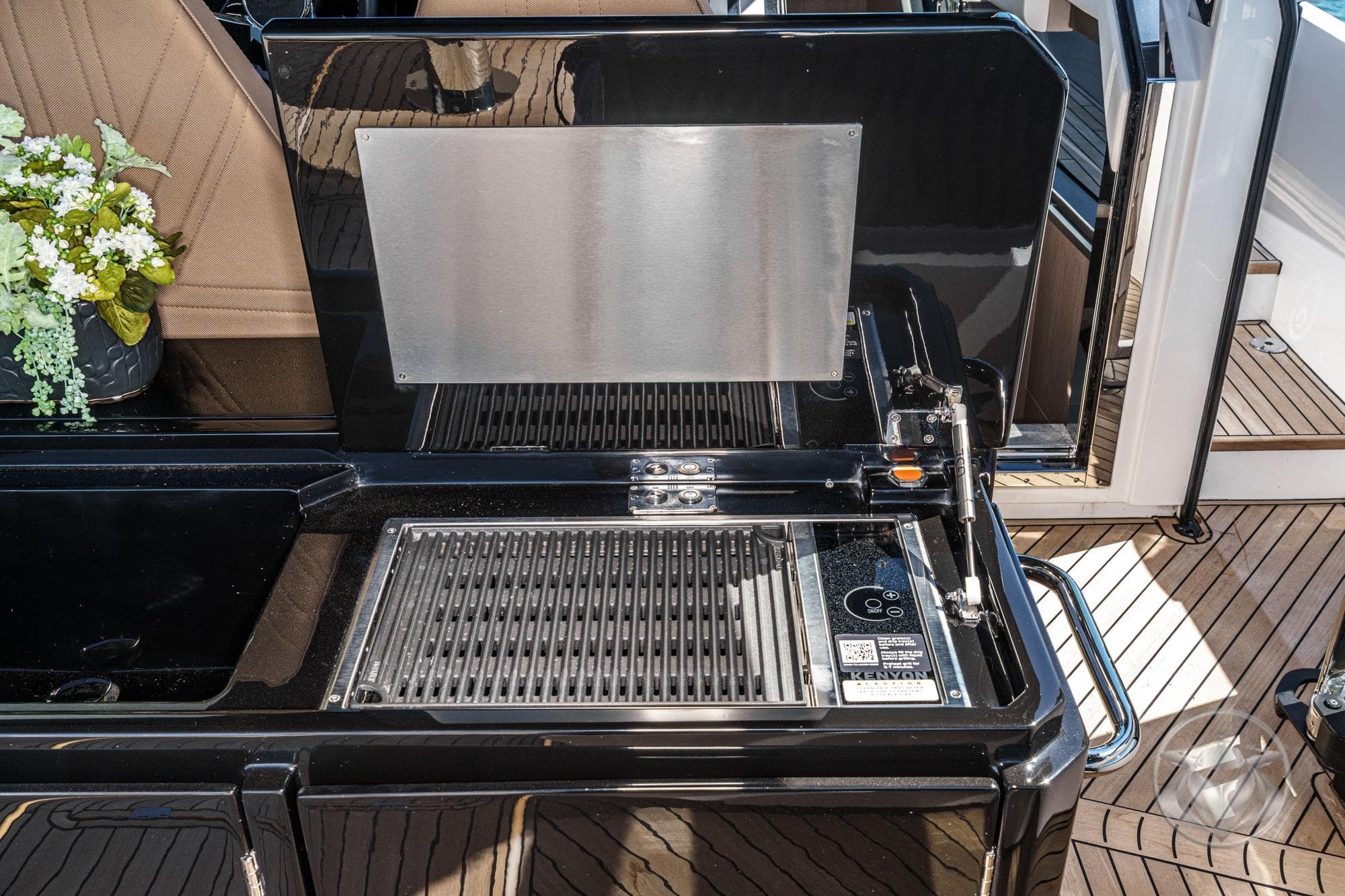 Outdoor kitchen area on 2026 Sunseeker Superhawk 55 yacht with grill and seating.