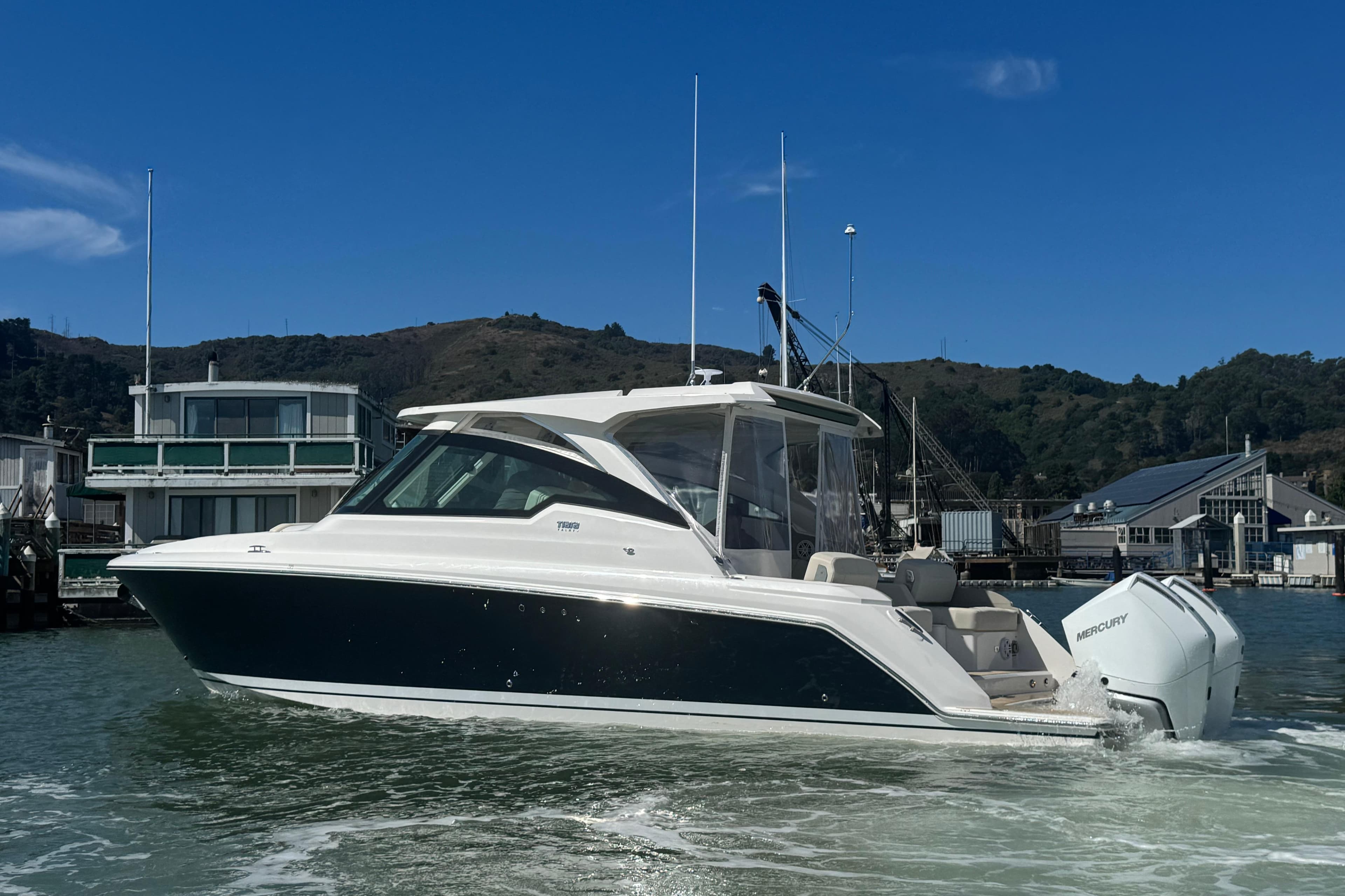 2026 Tiara Yachts 34 LX cruising in a marina with scenic background.