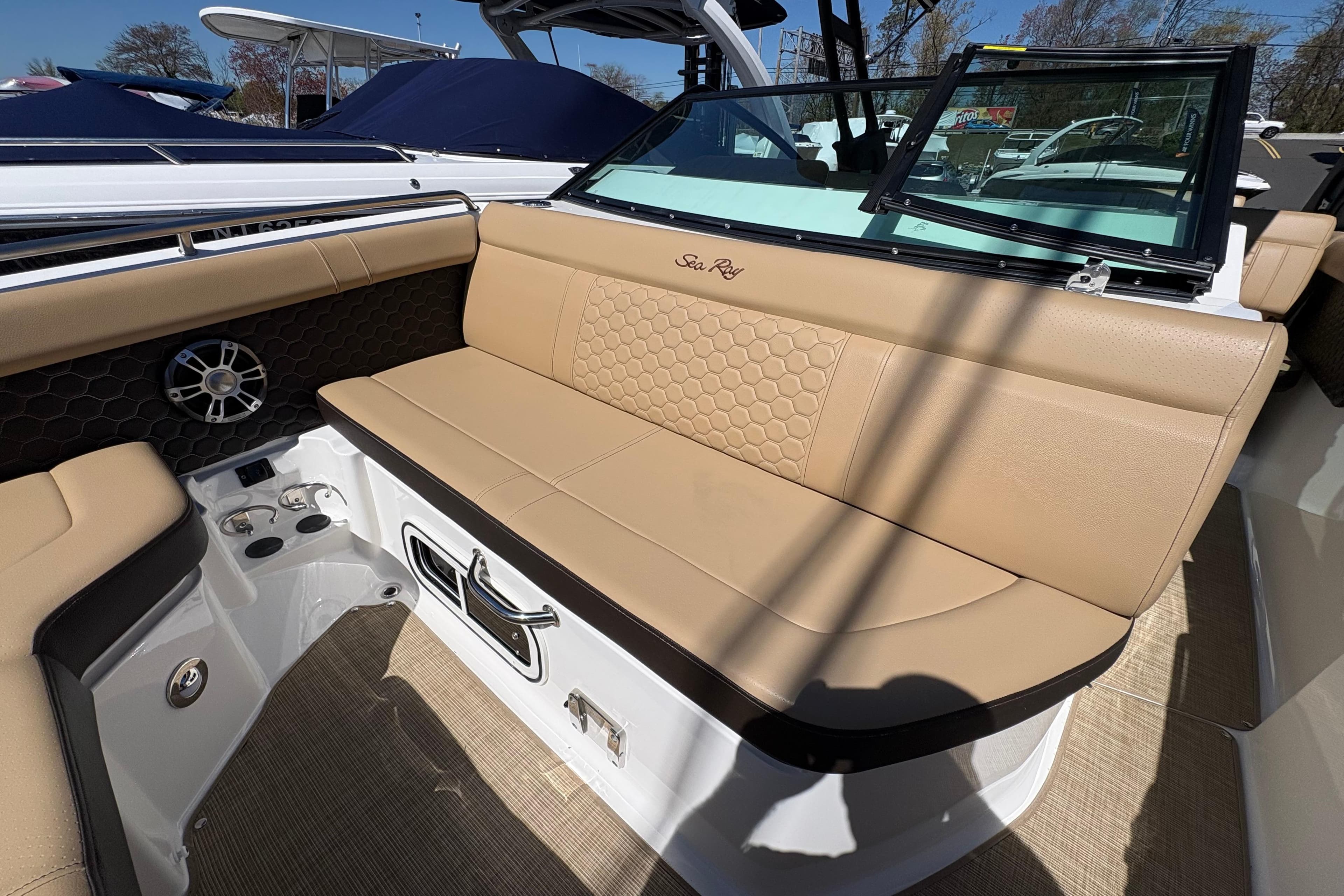 2024 Sea Ray SDX 250 Outboard boat interior with tan seating and speaker system.