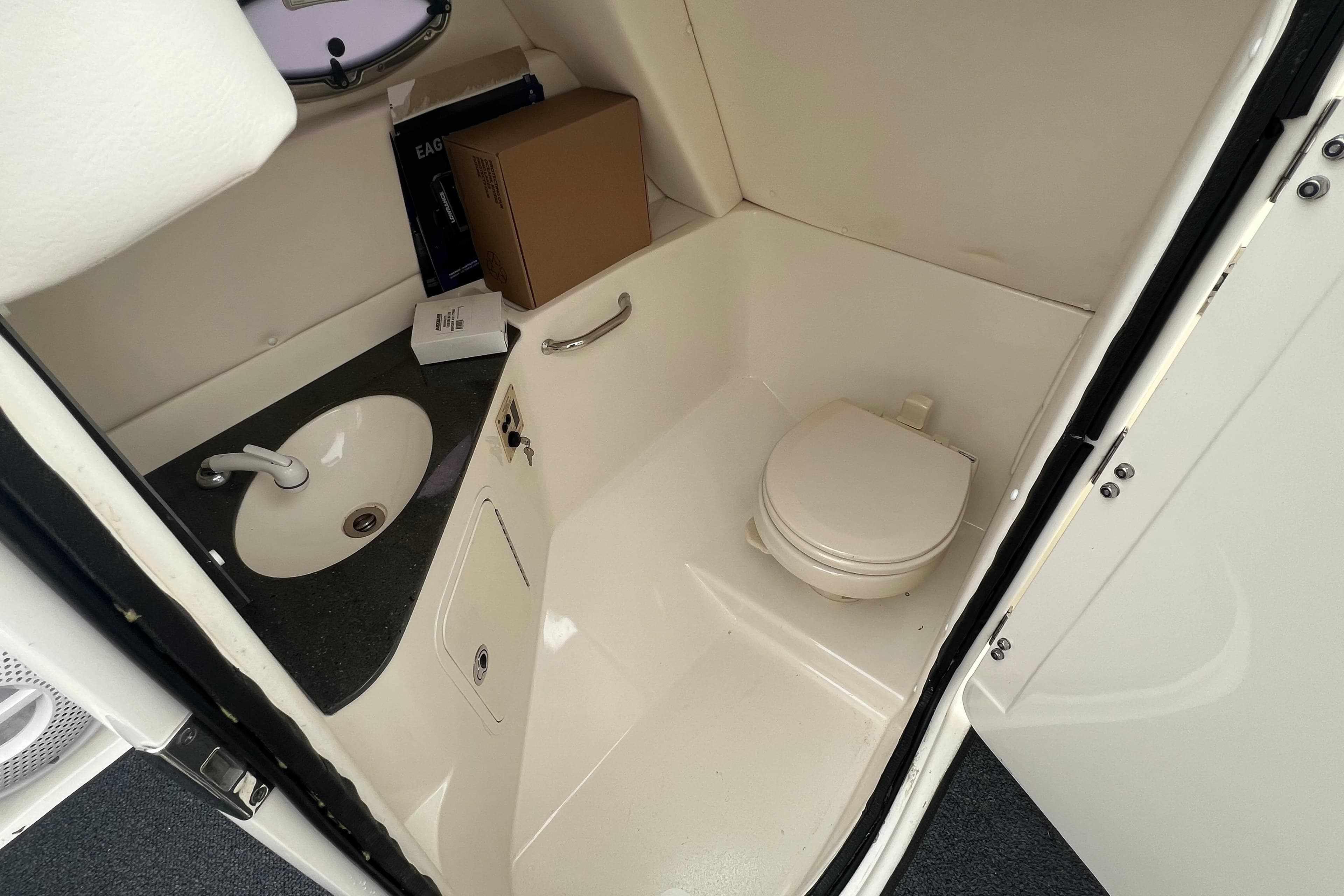 Interior of 2011 Sea Ray 300 Sundeck boat bathroom with sink and toilet.