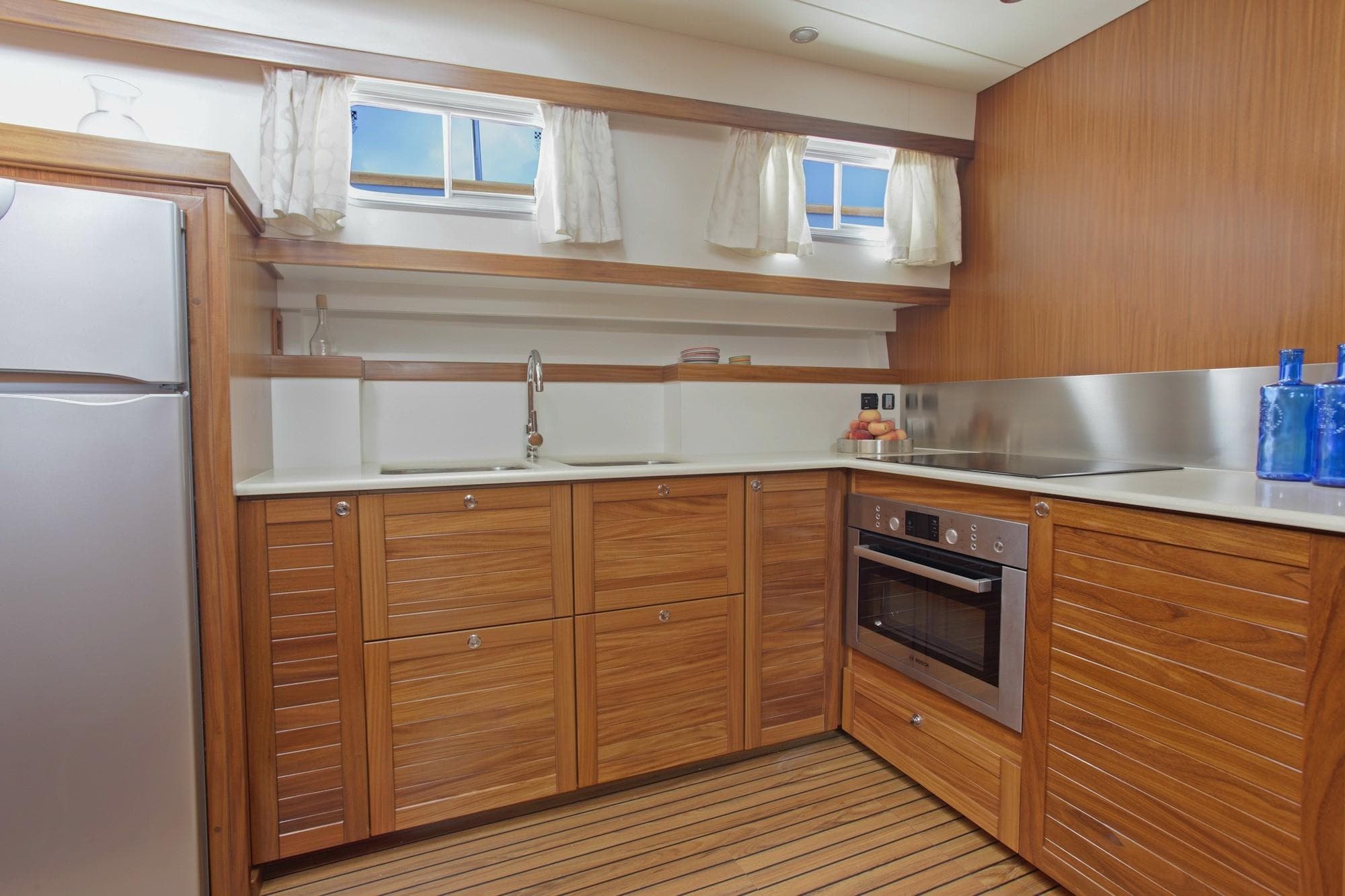 Modern kitchen interior on 2026 Sasga Yachts 55, featuring wood cabinetry and stainless steel appliances.