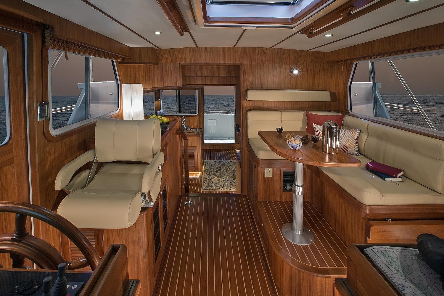 Interior of 2025 Helmsman Trawlers 38E Pilothouse with elegant wood finish and seating area.