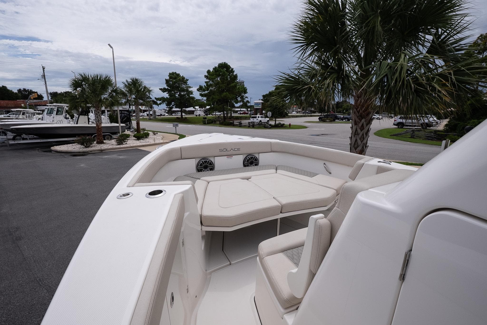 2026 Solace 30 CS boat with spacious seating, docked near palm trees.