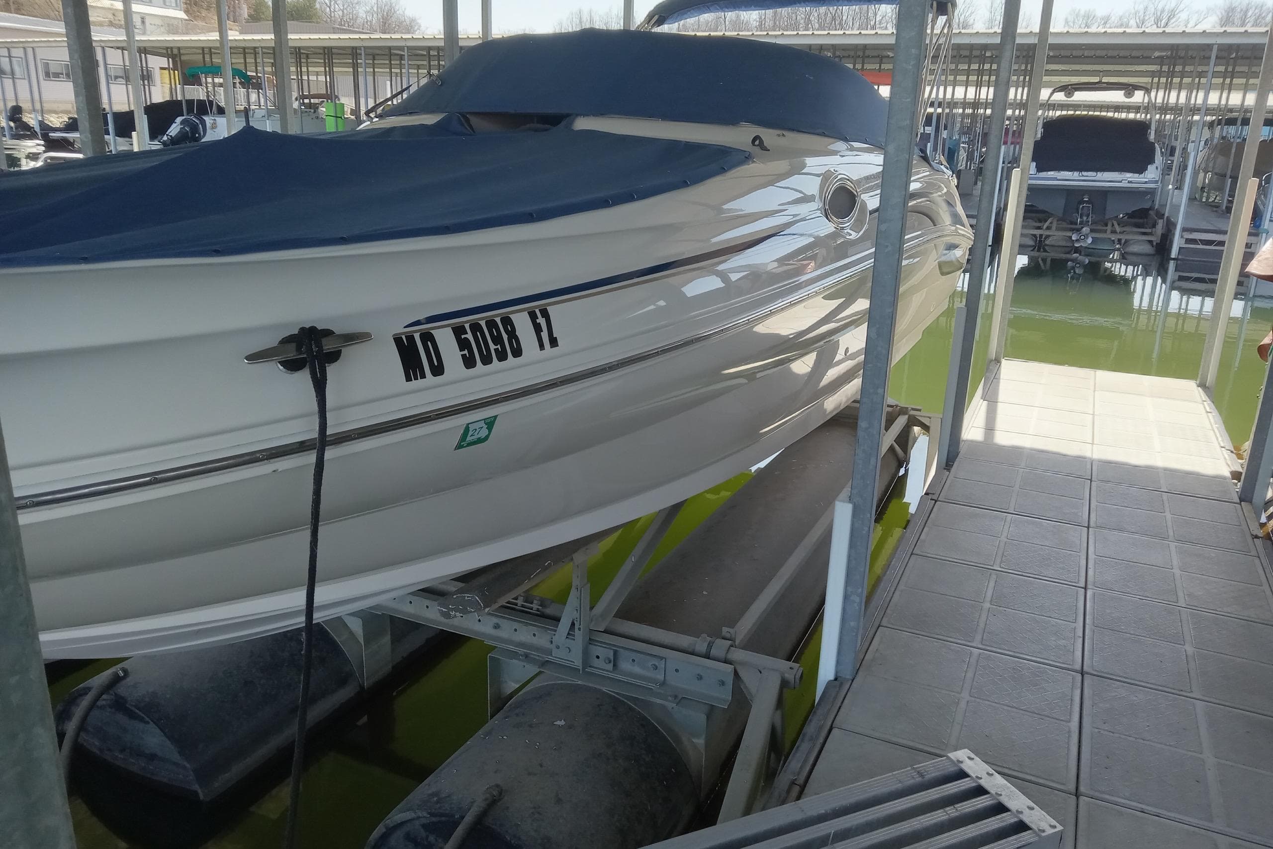 2001 Sea Ray 240 Sundeck boat docked in a marina with cover.