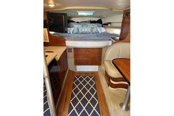 2002 Rinker 342 Fiesta Vee cabin interior with cozy bed and dining area.